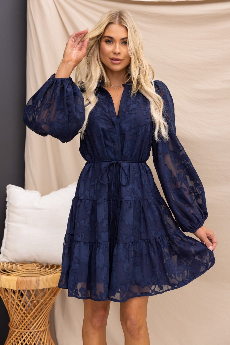 Navy Halston dress with embossed print, button-up front, and elastic cuffs, styled with a removable fabric tie.