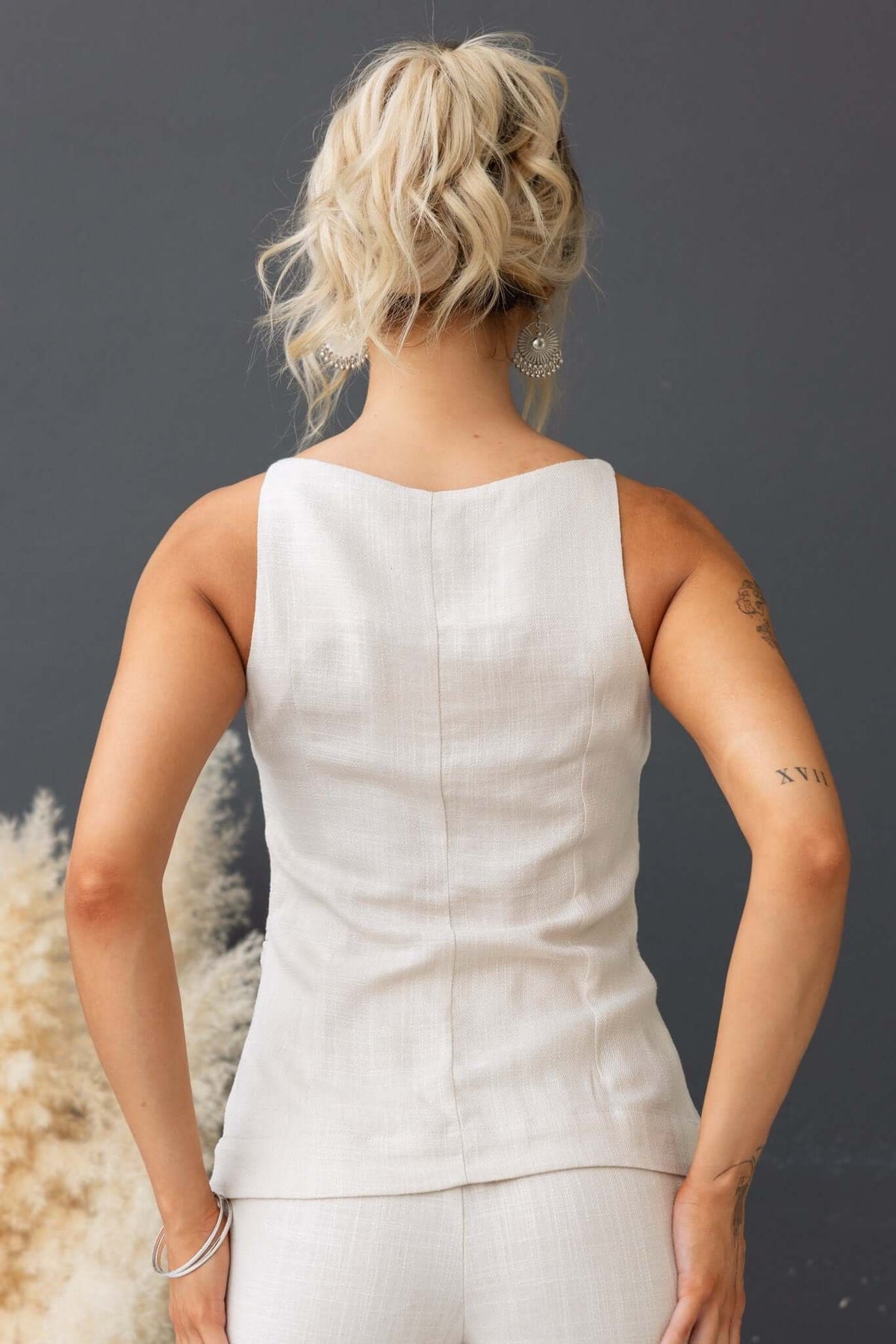 Back view of a woman wearing a light-colored Shelton Top, showcasing its elegant design and fit.