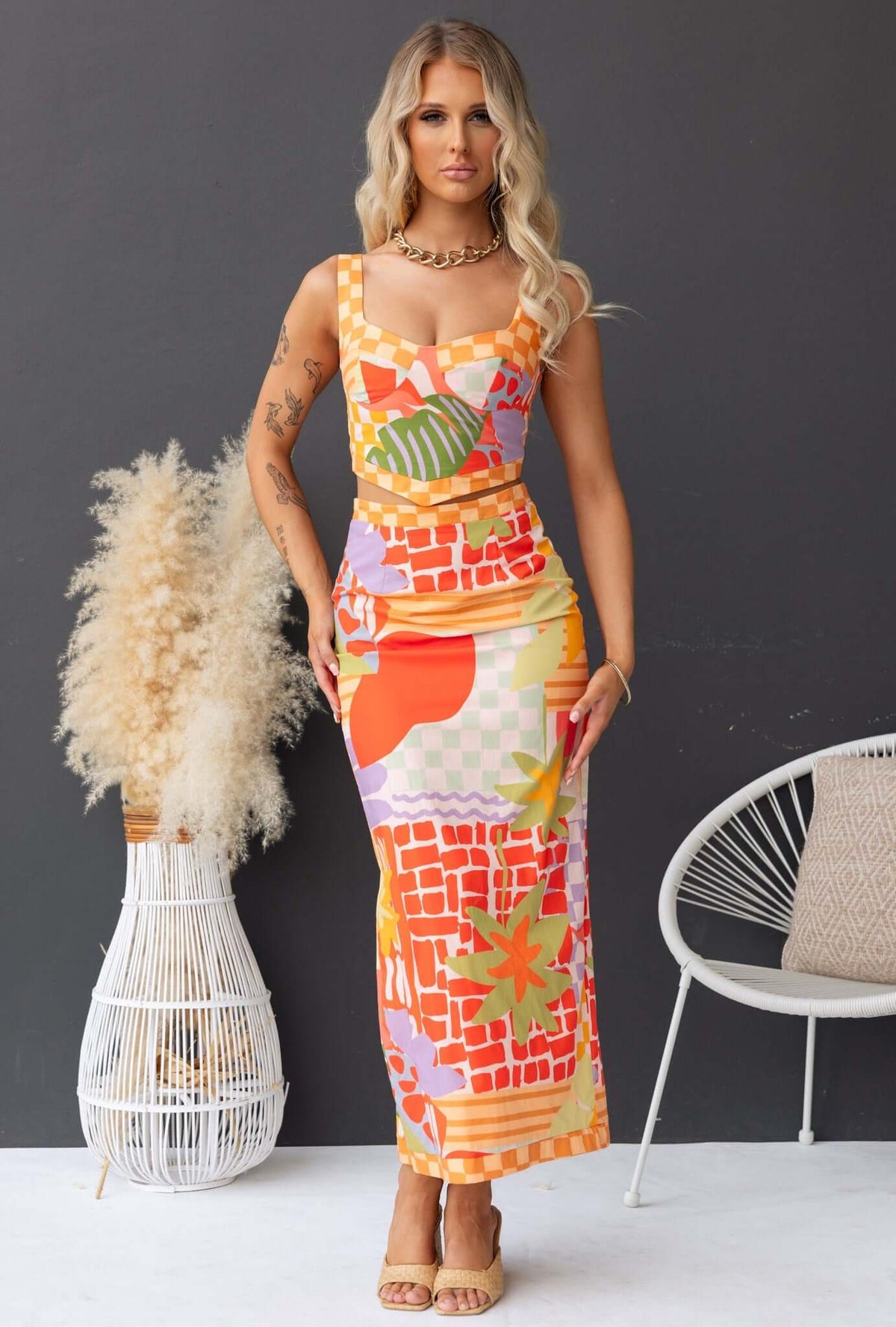 Woman modeling a colorful Paltrow Set with adjustable straps and a non-stretch maxi skirt, perfect for summer occasions.