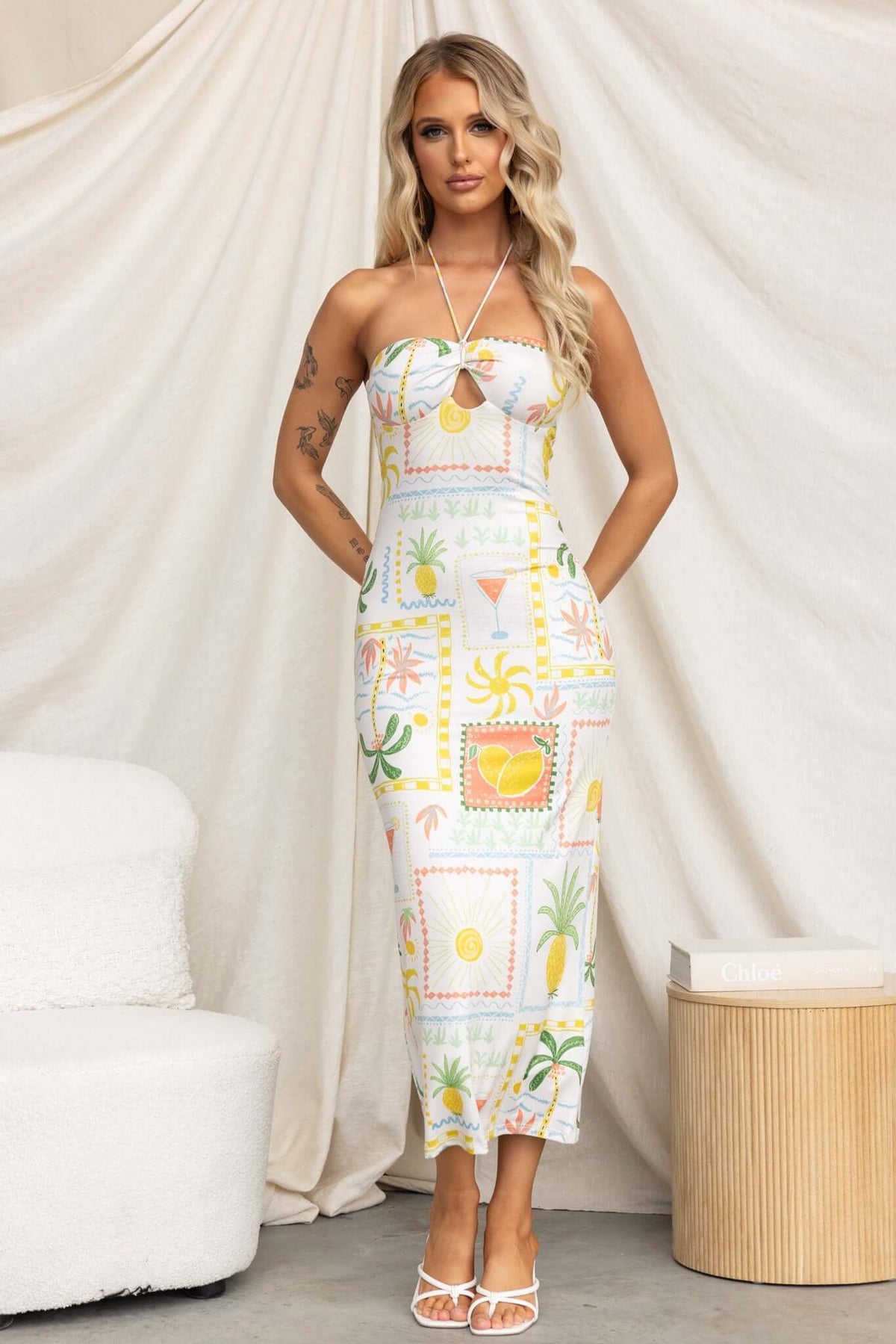 Strapless Carianne Midi Dress featuring tropical print, tie neckline, and a fitted silhouette against a neutral backdrop.