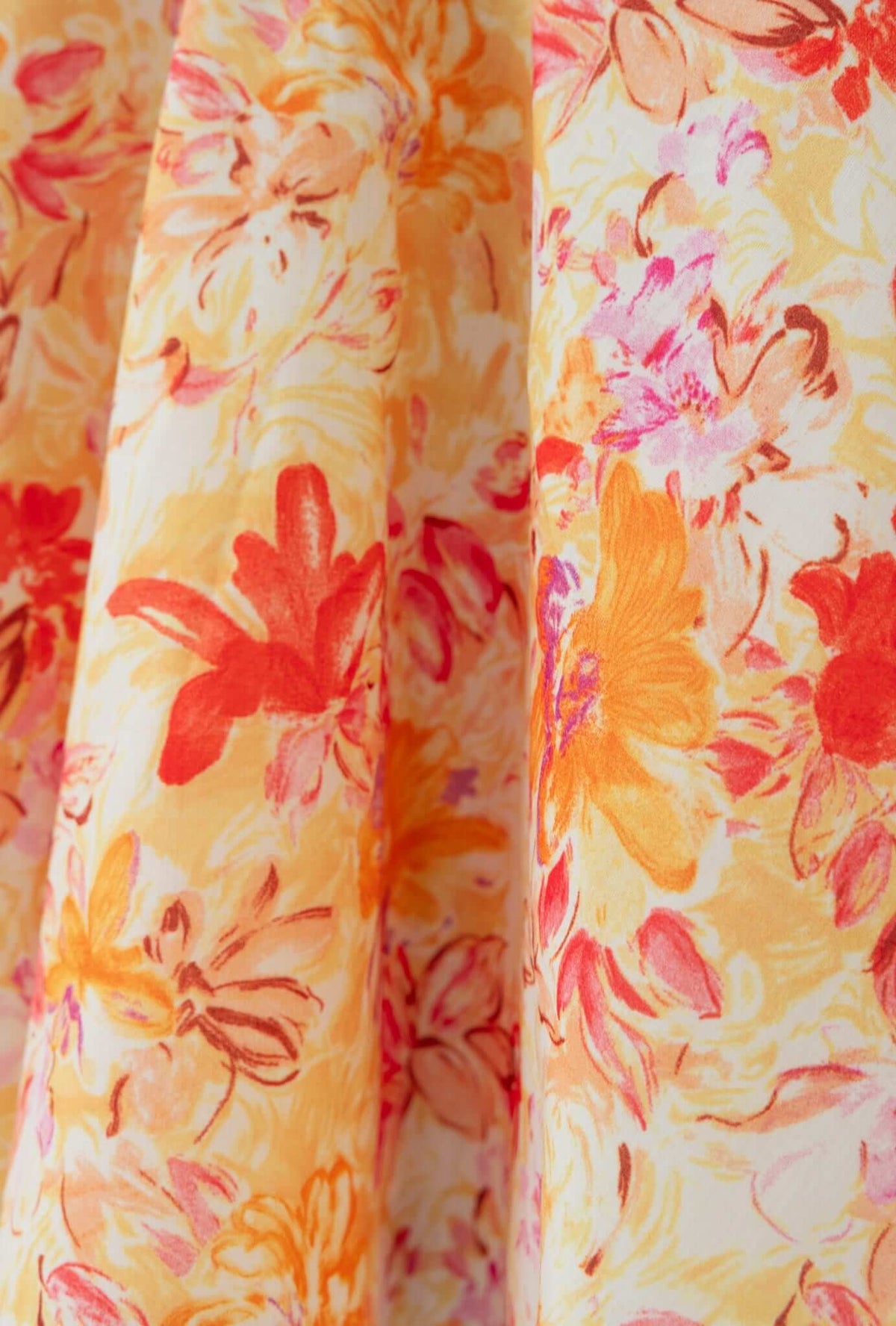 Close-up of floral fabric featuring vibrant orange and pink flowers on a light background for Elixir Dress
