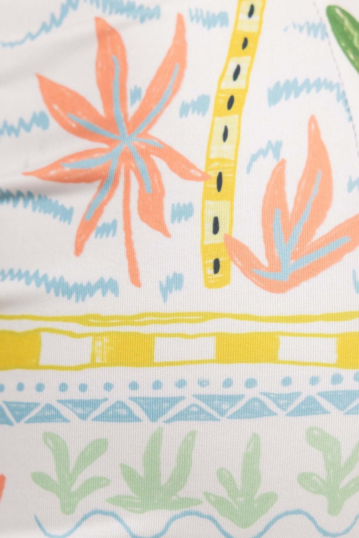 Colorful floral print detail featuring orange and blue flowers on a white background in a stylish design.