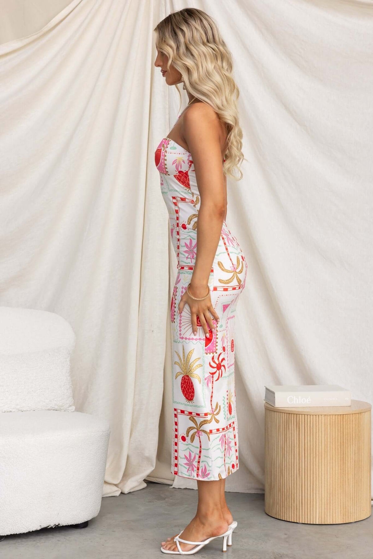 Side view of Carianne Midi Dress featuring a strapless design and vibrant floral patterns, perfect for summer occasions.