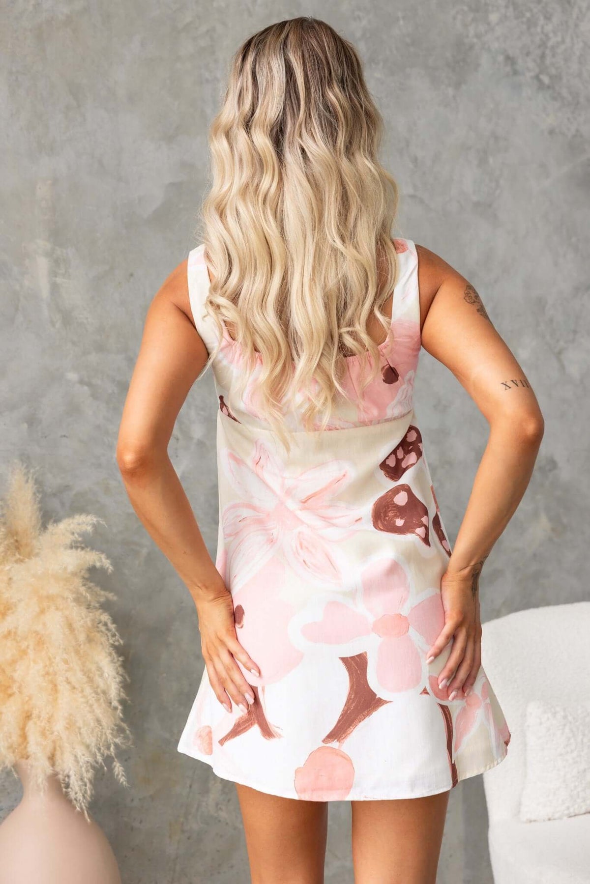 Back view of a woman in the Hathaway Dress, featuring floral patterns and a relaxed fit.