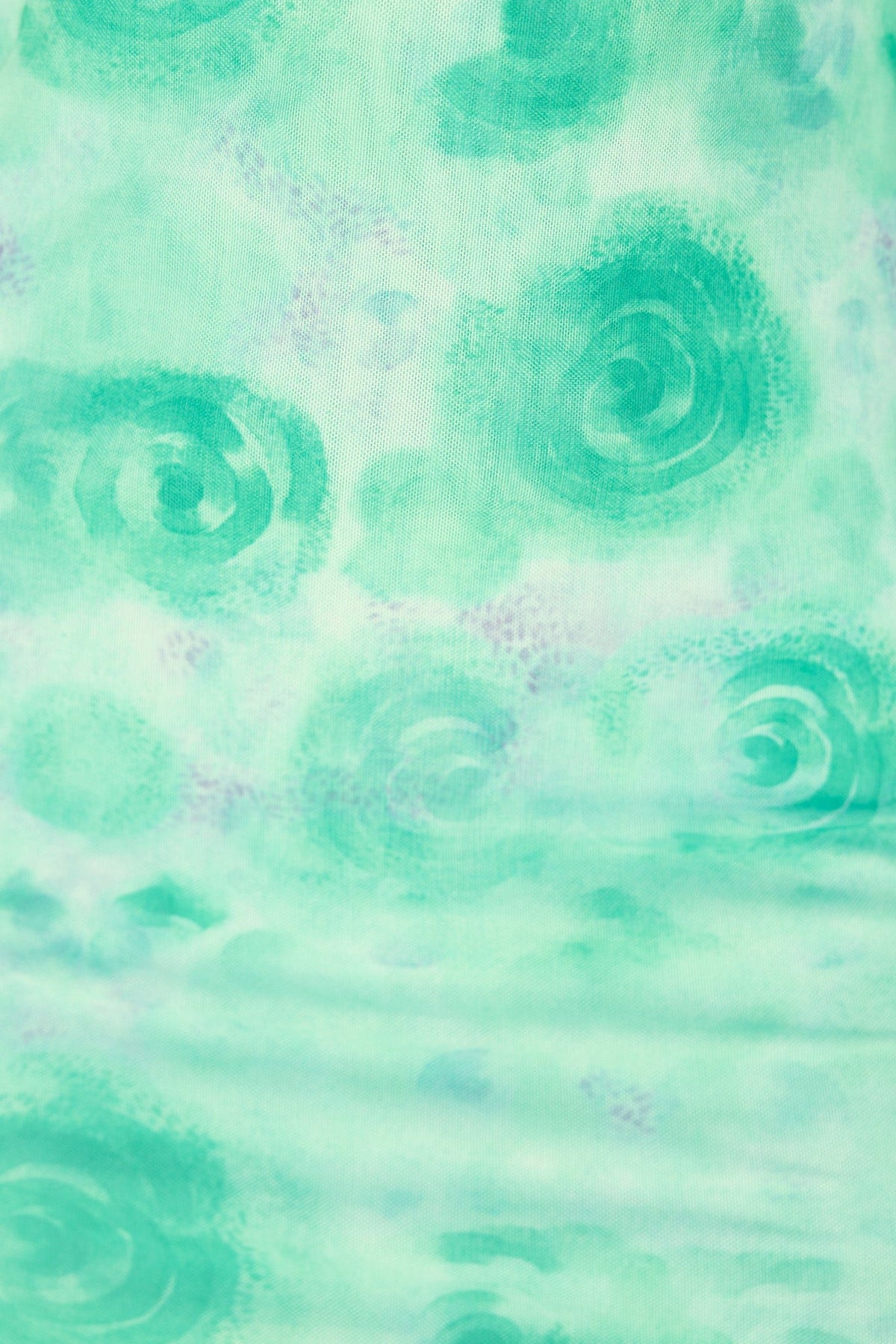 Close-up of Sorriso Midi Dress fabric featuring a soft mint green pattern with swirling designs.