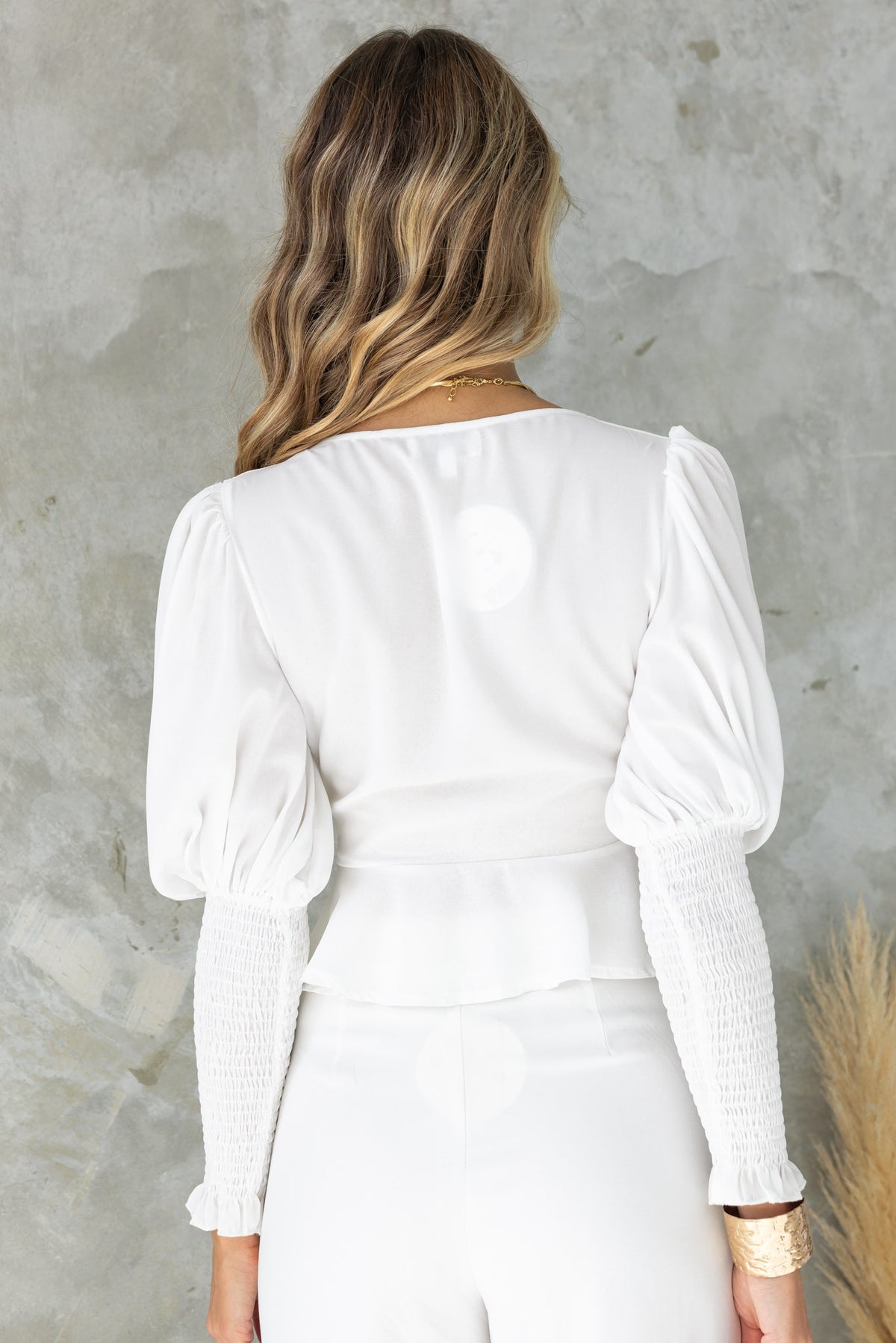 Model wearing Fleur Top from the back, showcasing its puff sleeves and elegant design.