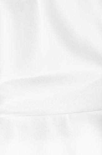 Close-up of smooth white fabric, showcasing its soft texture, ideal for a stylish Fleur Top.