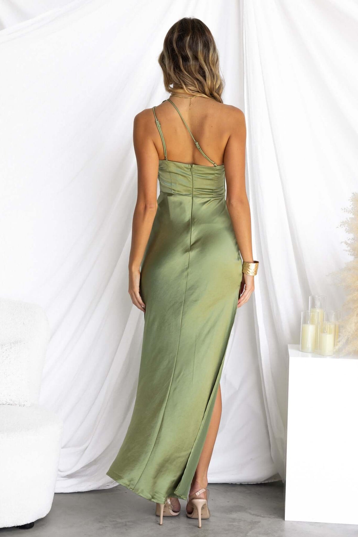 Ainaz Maxi Dress in olive green, showcasing a one-shoulder design and split front, worn by a model from the back.