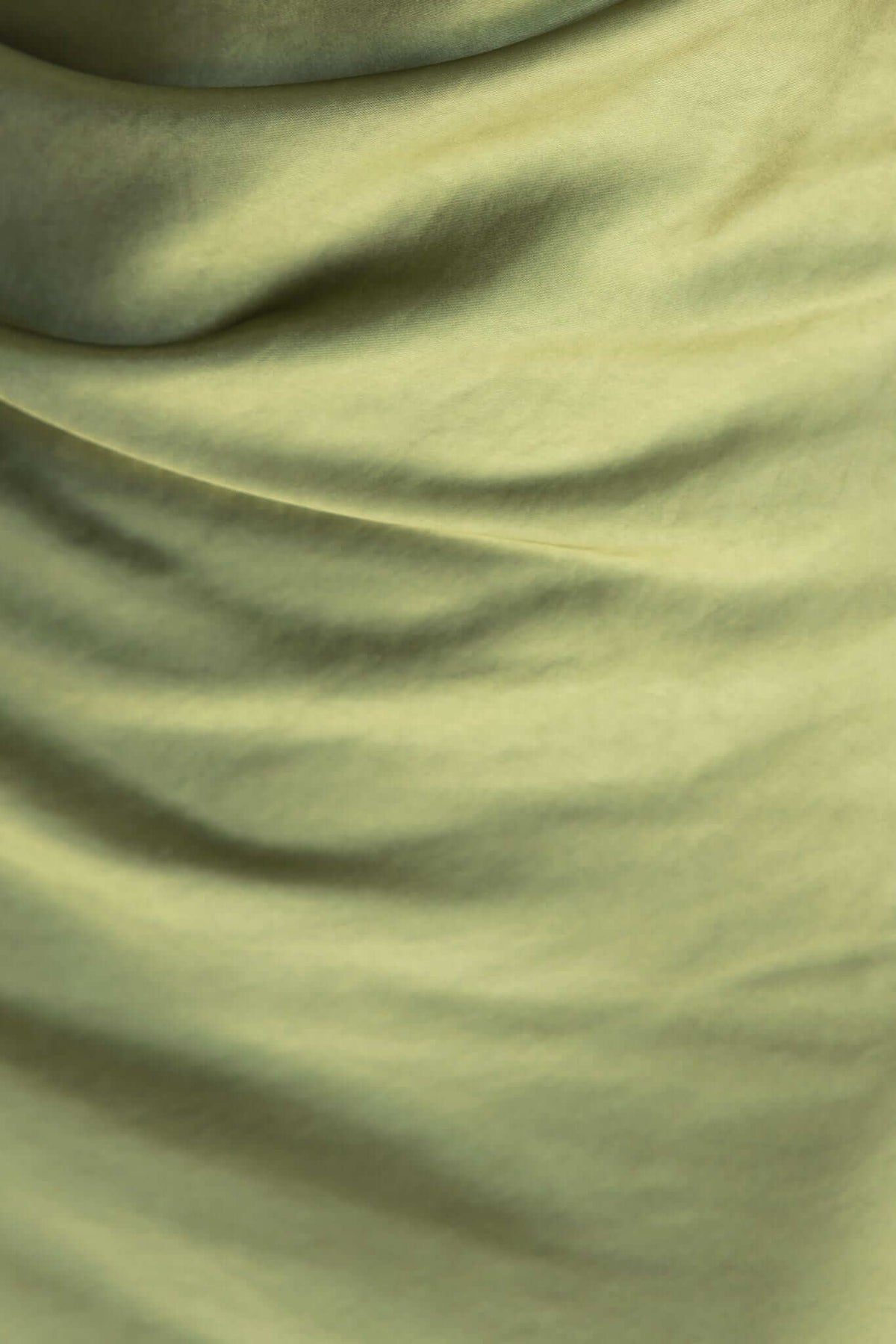 Close-up of soft, draped green fabric showcasing a satin look, ideal for elegant clothing like the Ainaz Maxi Dress.