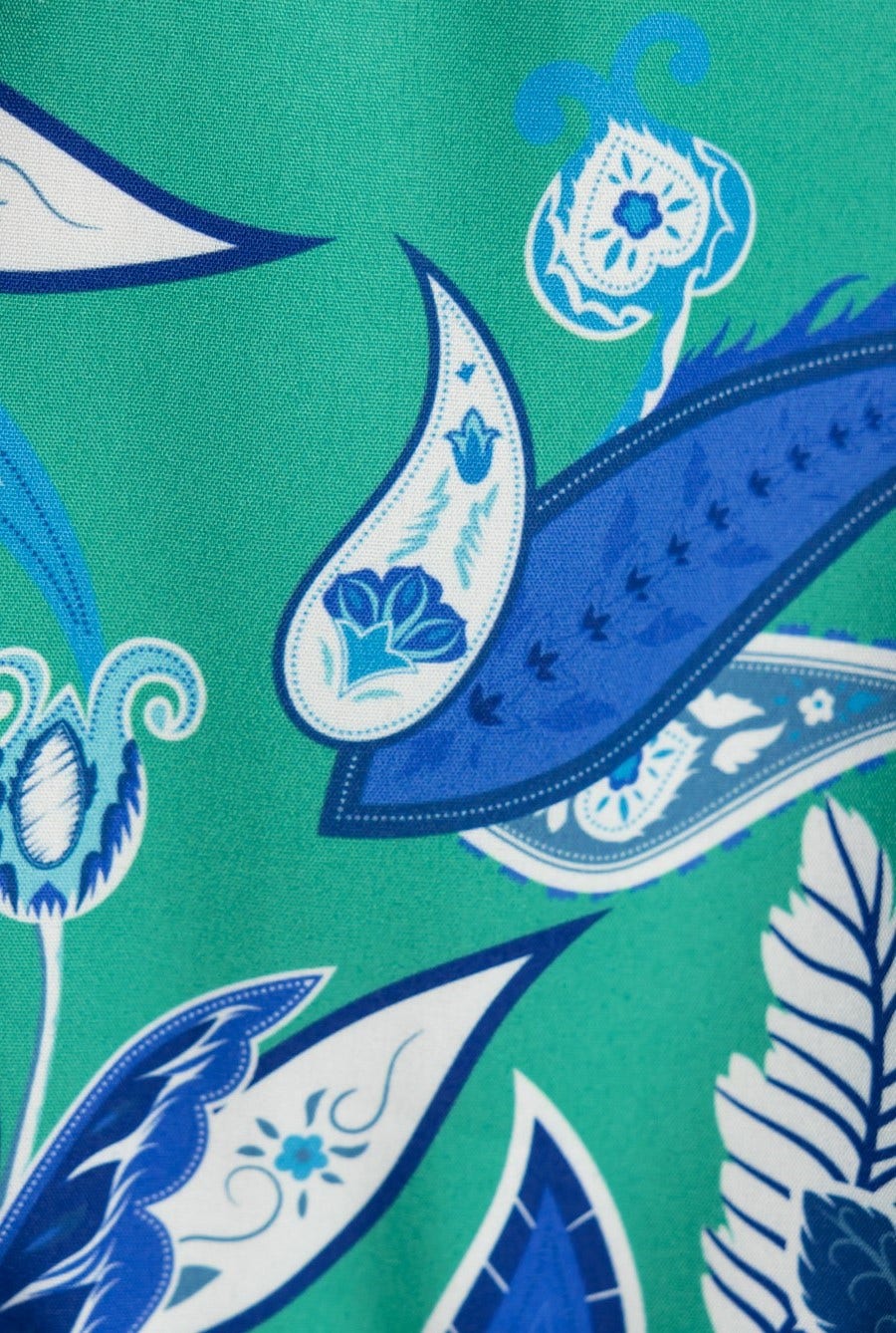Close-up of blue and green floral pattern design on fabric, showcasing intricate paisley and floral details.