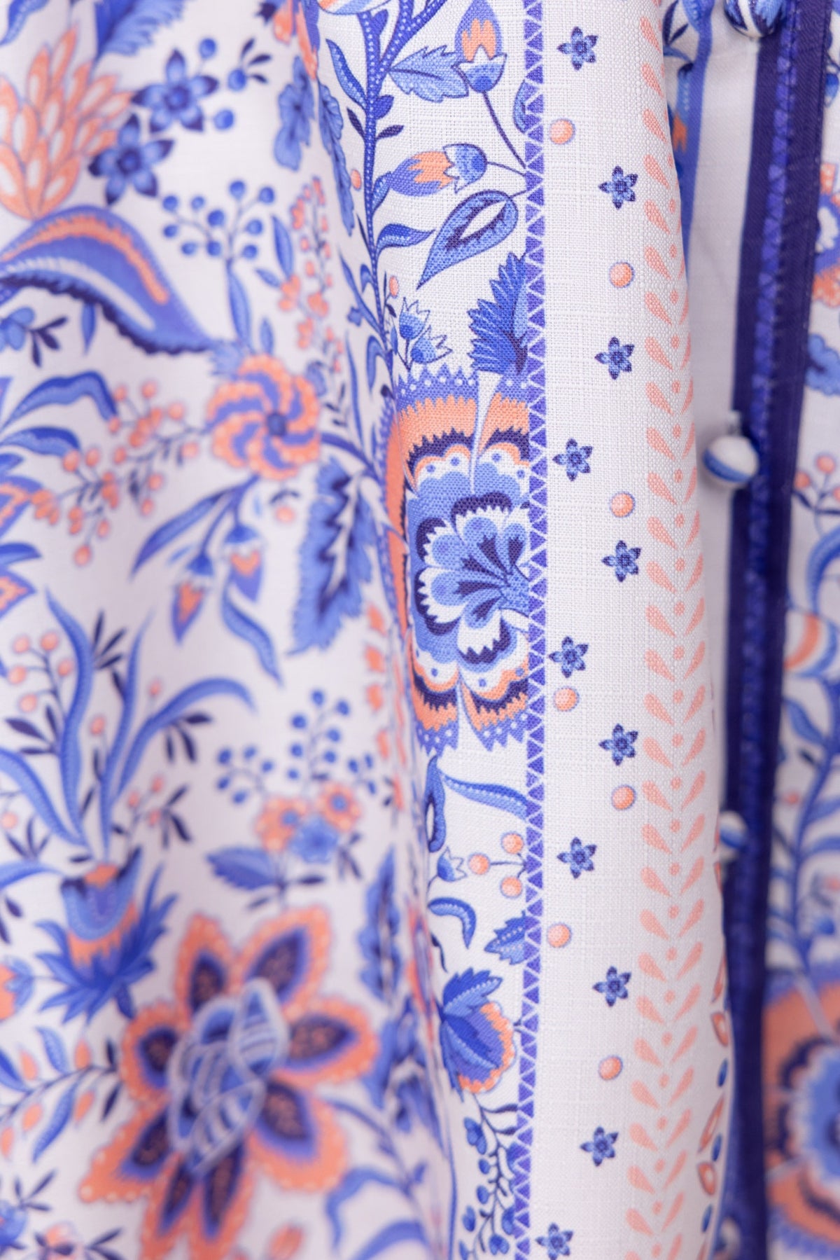 Close-up of floral patterned fabric in shades of blue and orange showcasing intricate design details.