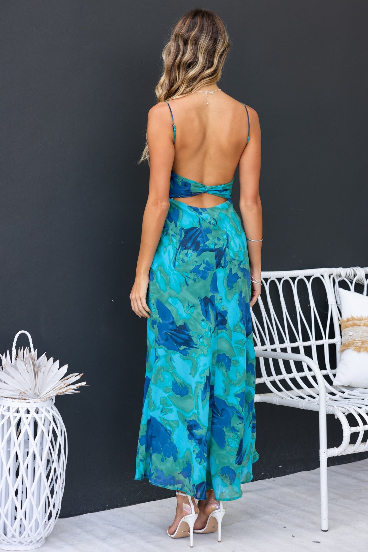 Model wearing Freyda Maxi Dress with floral print and adjustable straps, showcasing the back cut-out and flowy design.