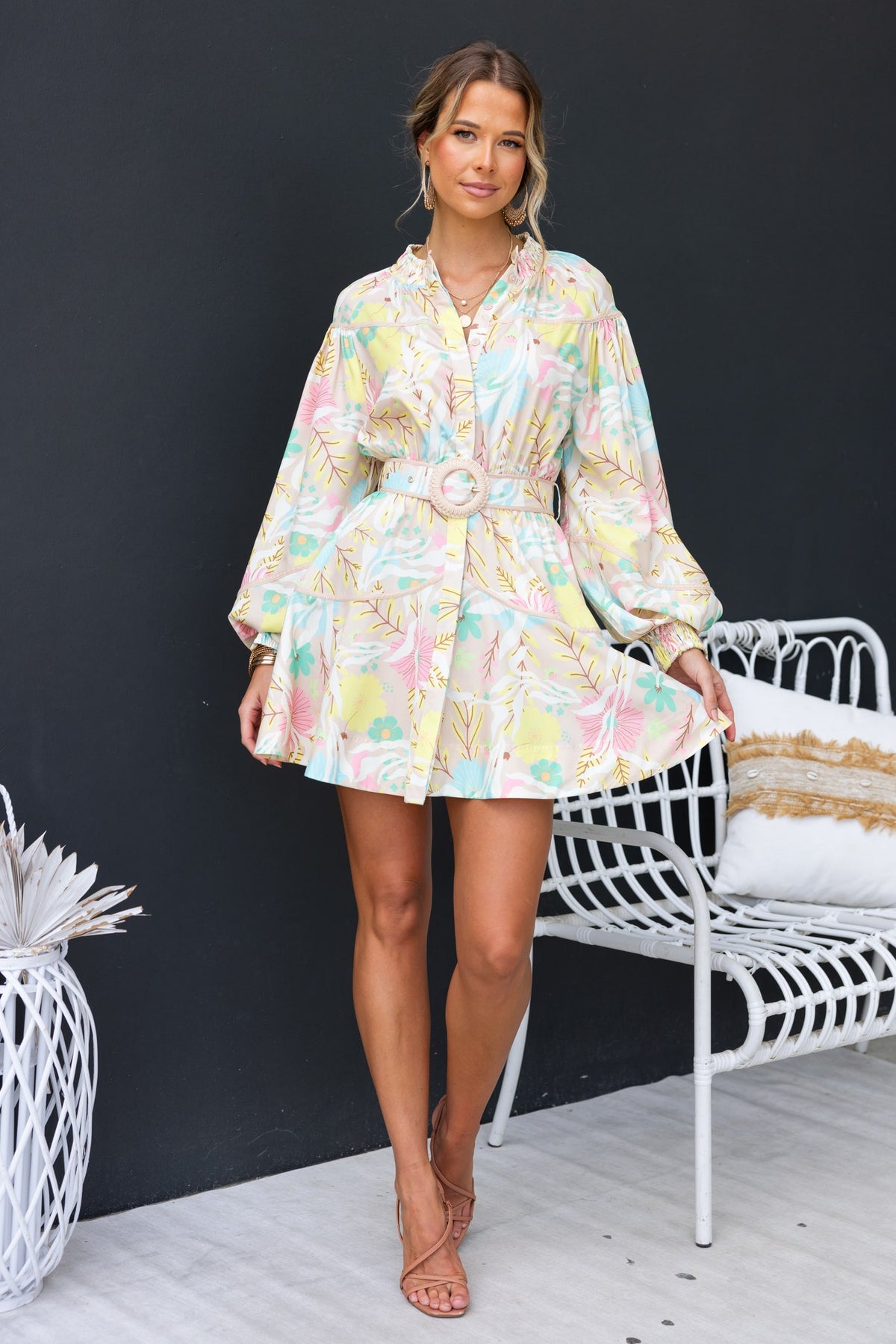 Model wearing Antonia Dress with elastic neckline, button-up front, and a removable belt against a black backdrop.