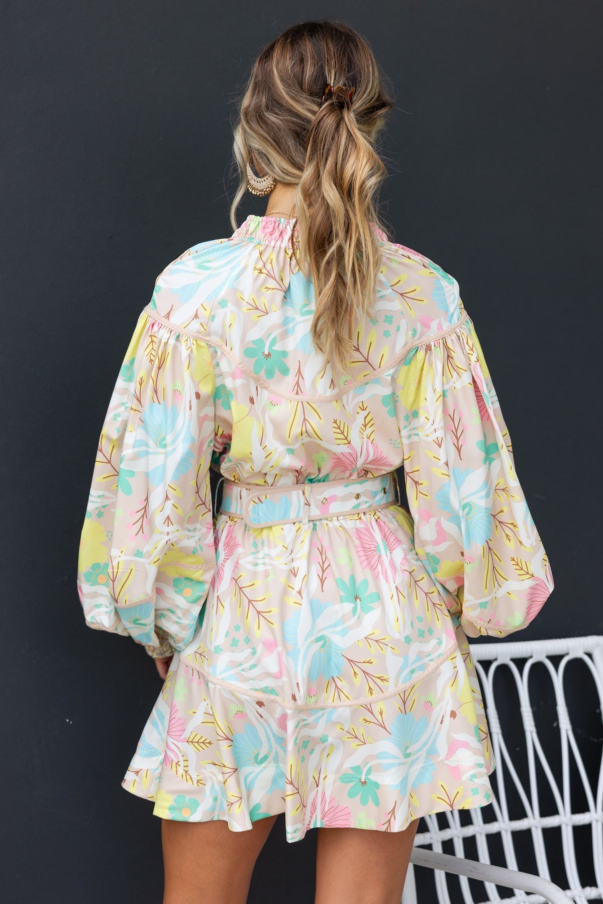 Back view of Antonia Dress with floral pattern, puff sleeves, and removable belt, showcasing a stylish and trendy design.