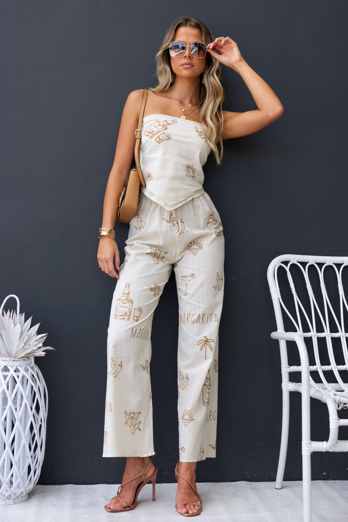 Model wearing the Tijuana Set with a stylish print, showcasing a versatile scarf-style top and mid-high waist pants.