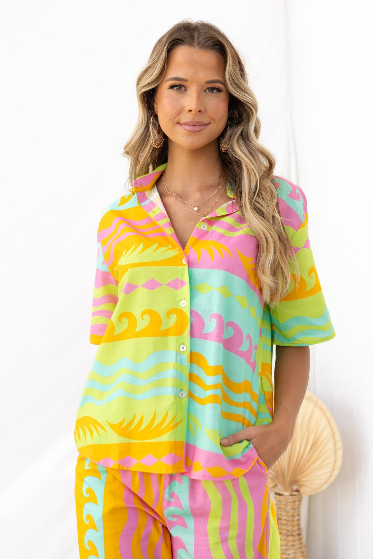 Verney Shirt featuring vibrant multicolored waves and patterns, modeled in a relaxed fit by a smiling woman.