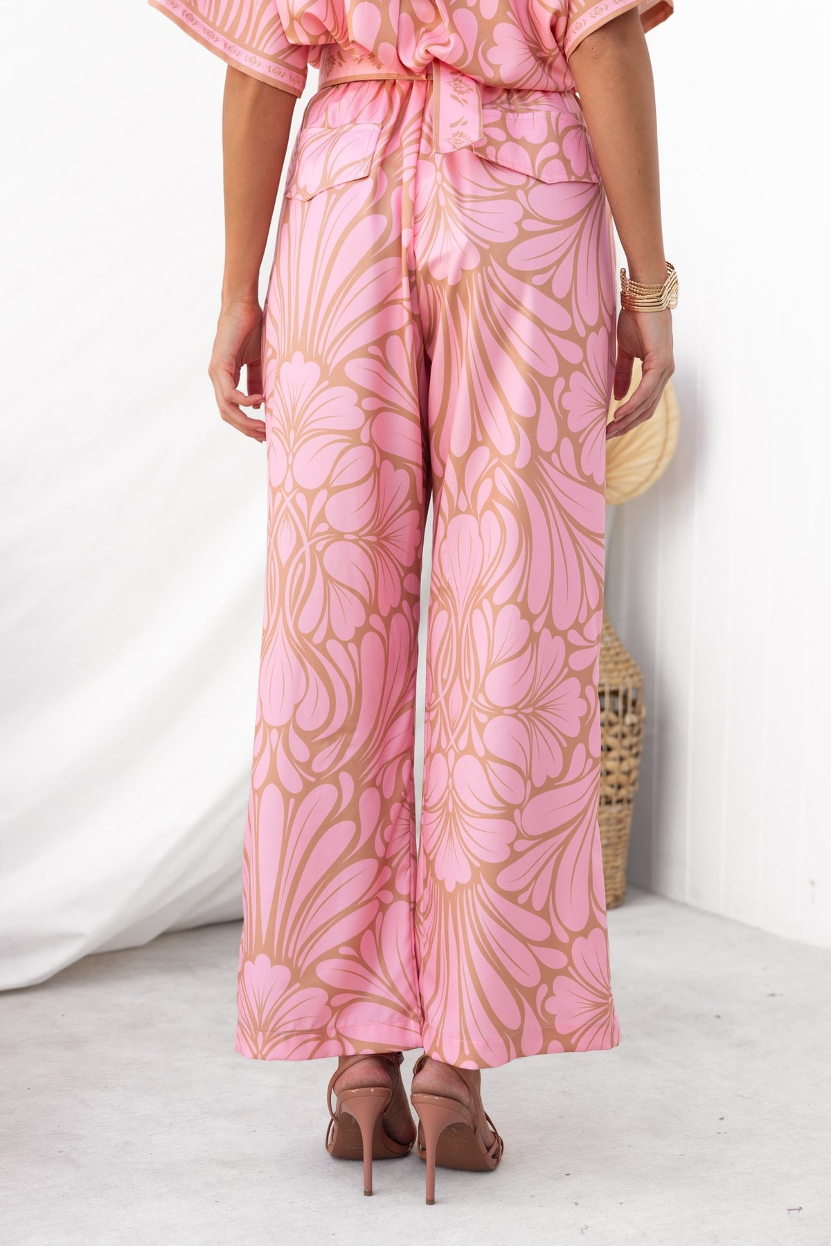Back view of Raddix Pants with pink floral pattern, featuring a removable belt and wide-leg design.