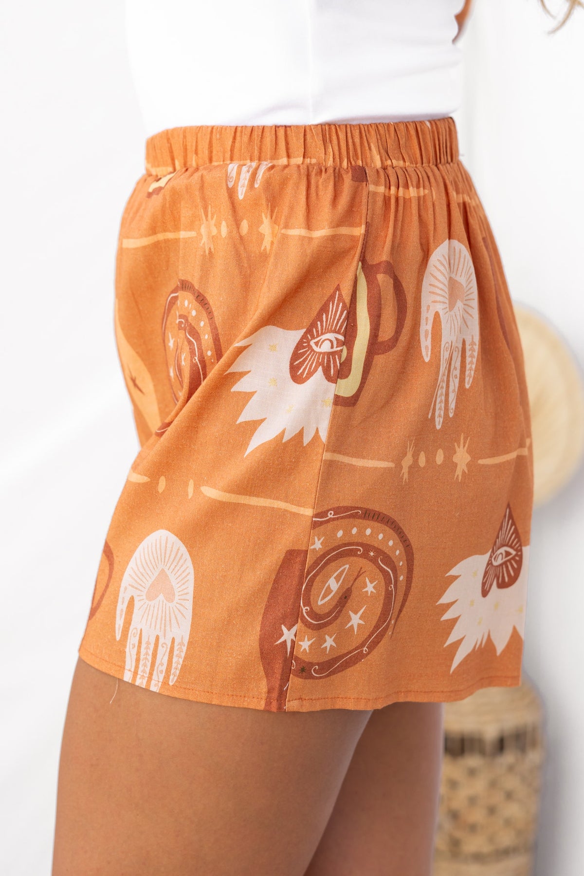 Rust-colored shorts with bohemian patterns and an elastic waistband, perfect for casual summer wear.