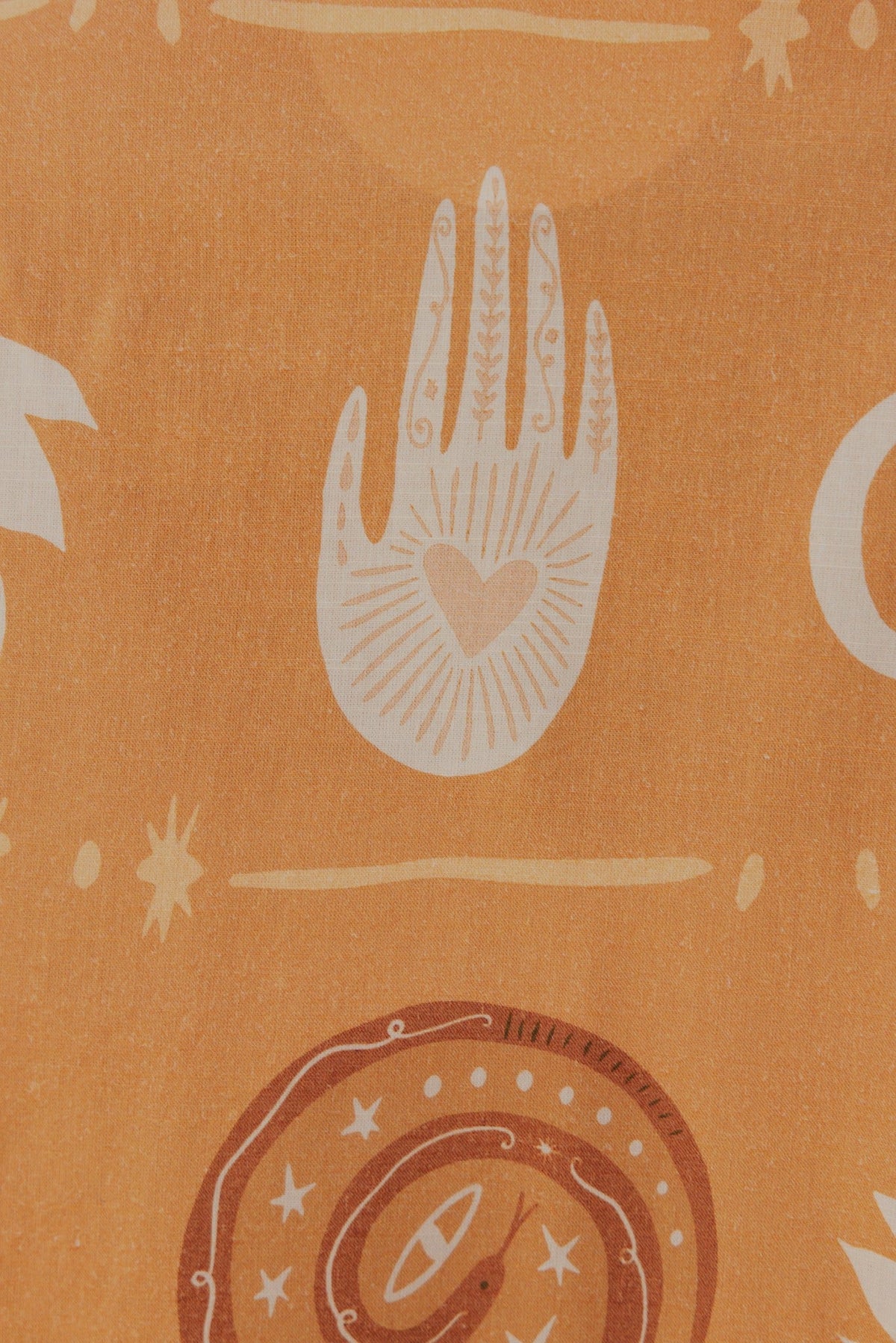 Pattern featuring a hand illustration with a heart design on an orange background, with various celestial motifs.