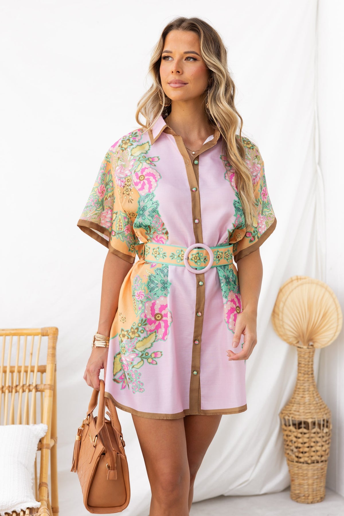 Woman wearing Jaziel Dress with floral pattern, collar, and removable belt, styled with a handbag.