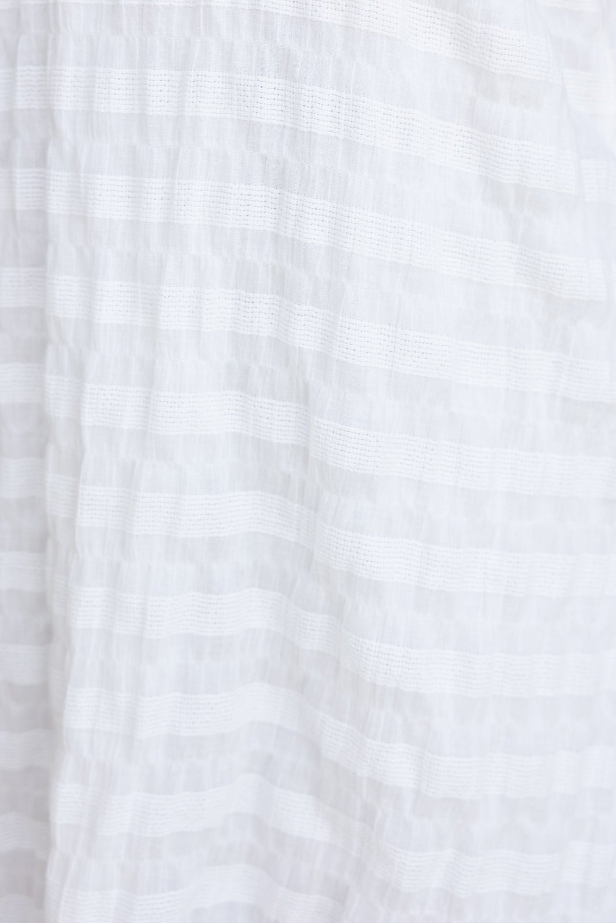 Close-up of textured white fabric featuring a striped pattern, ideal for the Italia Dress.
