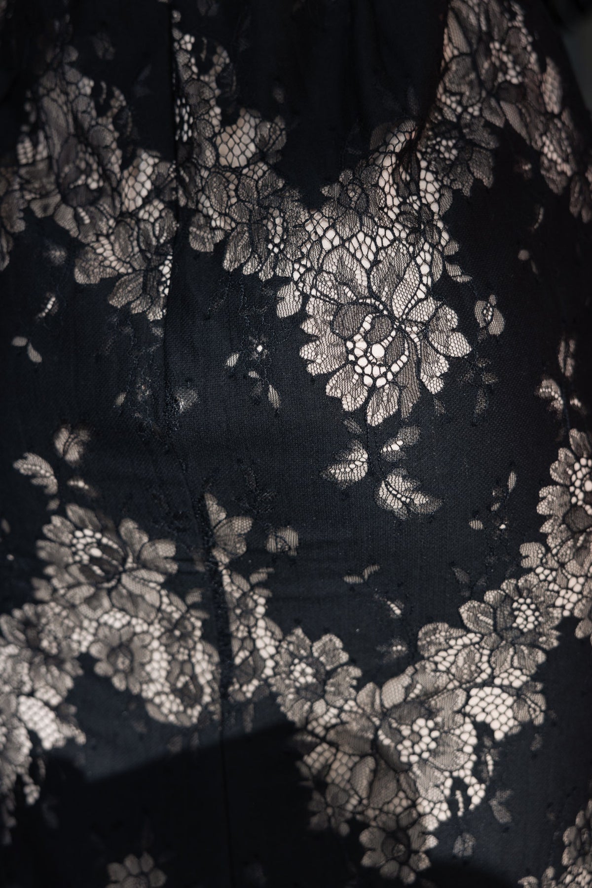 Close-up of intricate lace floral pattern on black fabric of the Seren Maxi Dress.