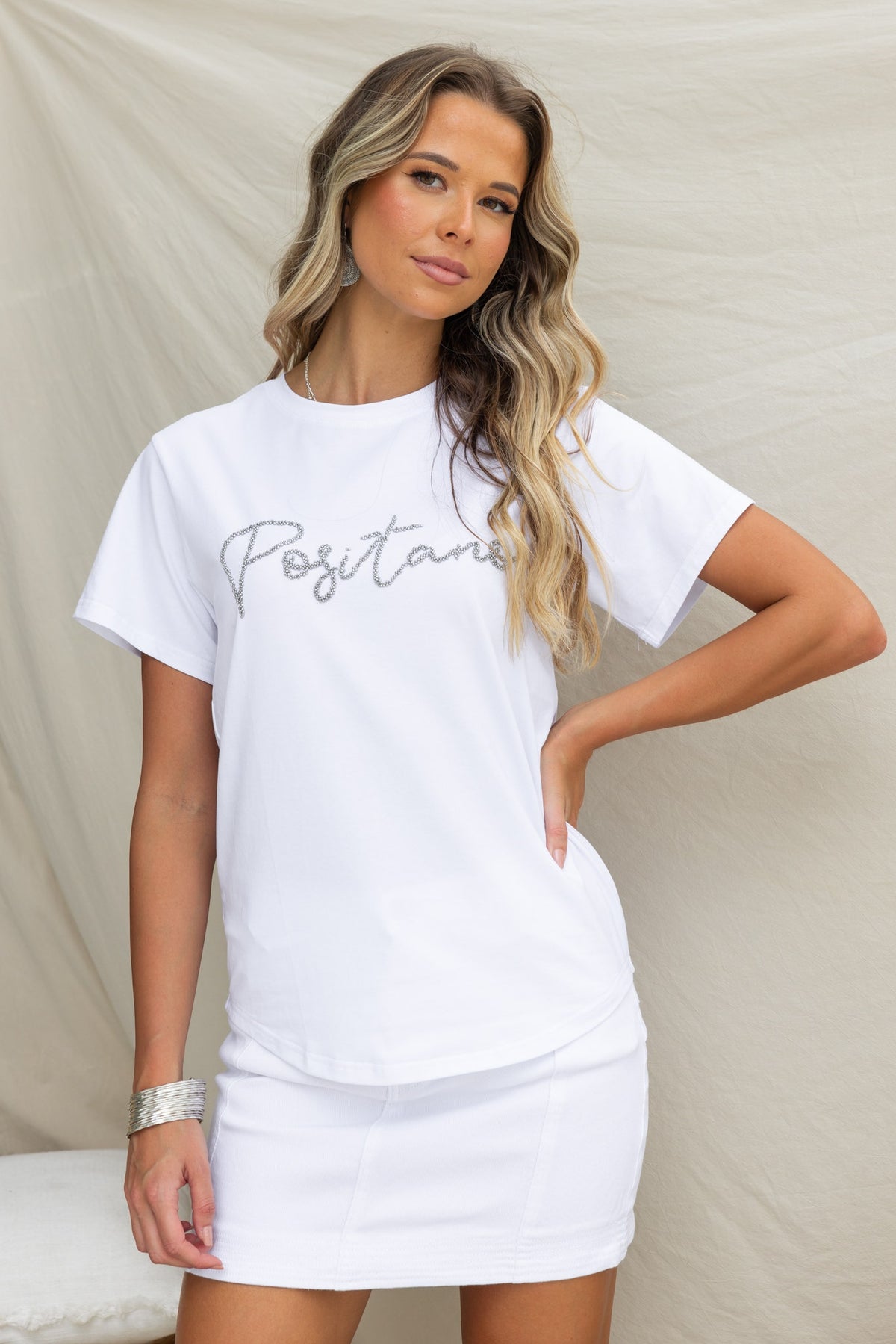 Model wearing white Landon Tee with 'Positano' print and round neckline, showcasing its soft cotton fabric.
