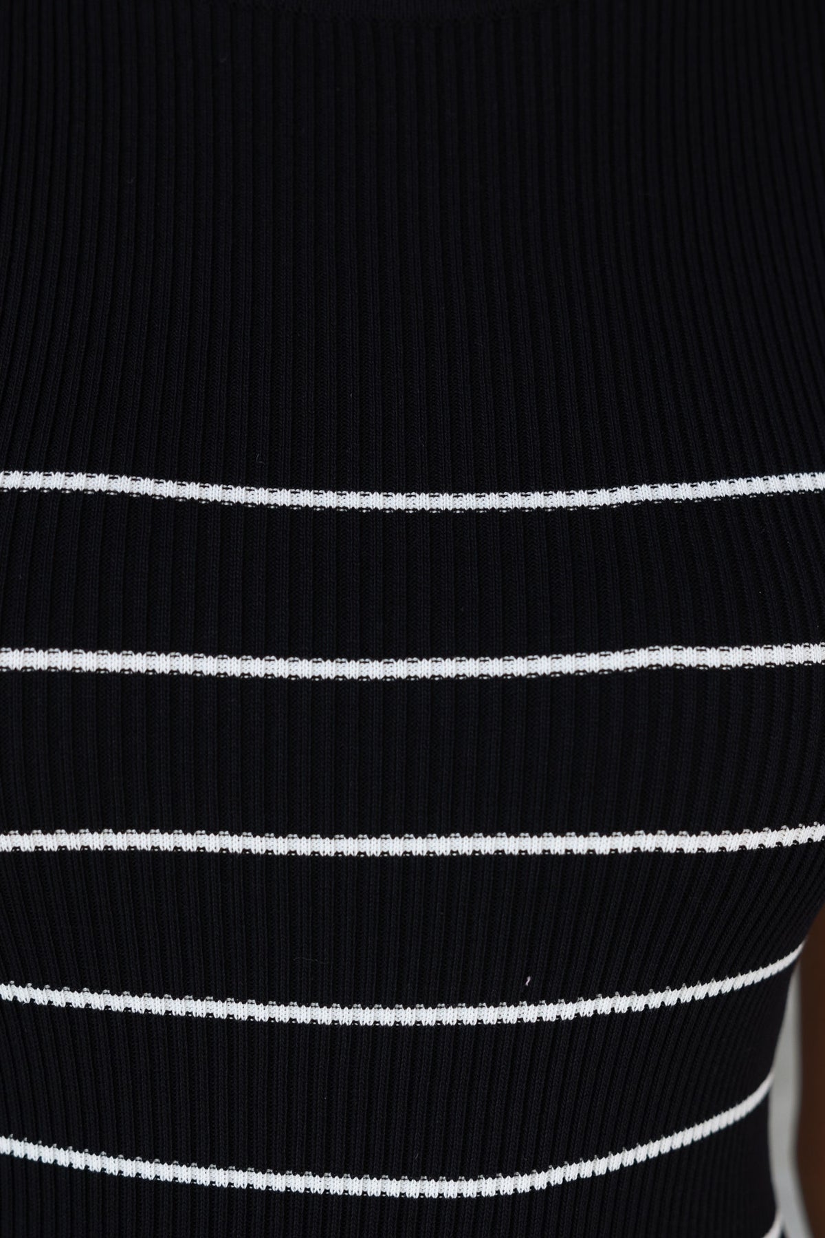 Close-up of black ribbed knit fabric with white stripes, showcasing the texture of the Siann Midi Dress.