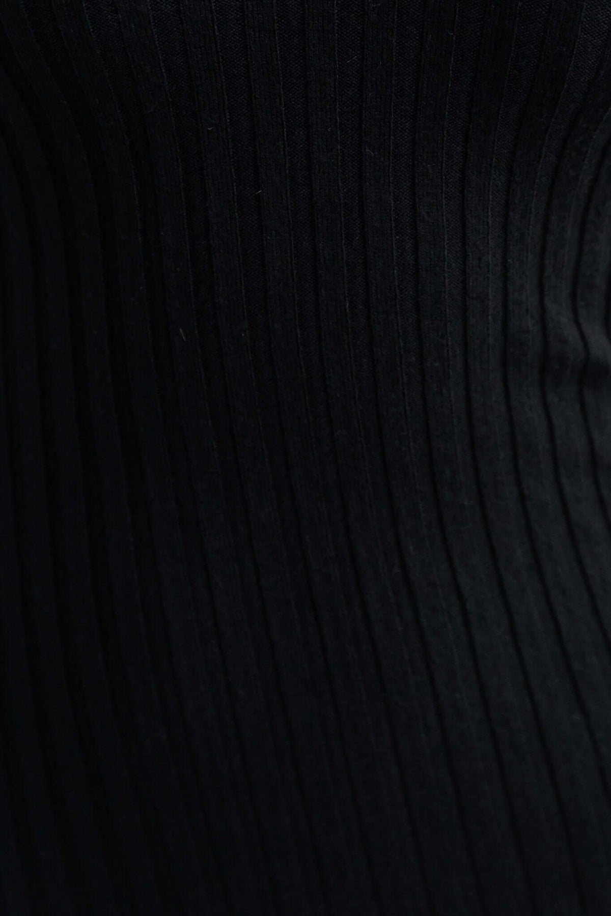Close-up of black ribbed knit fabric, showcasing the texture of the Aquino Midi Dress material.