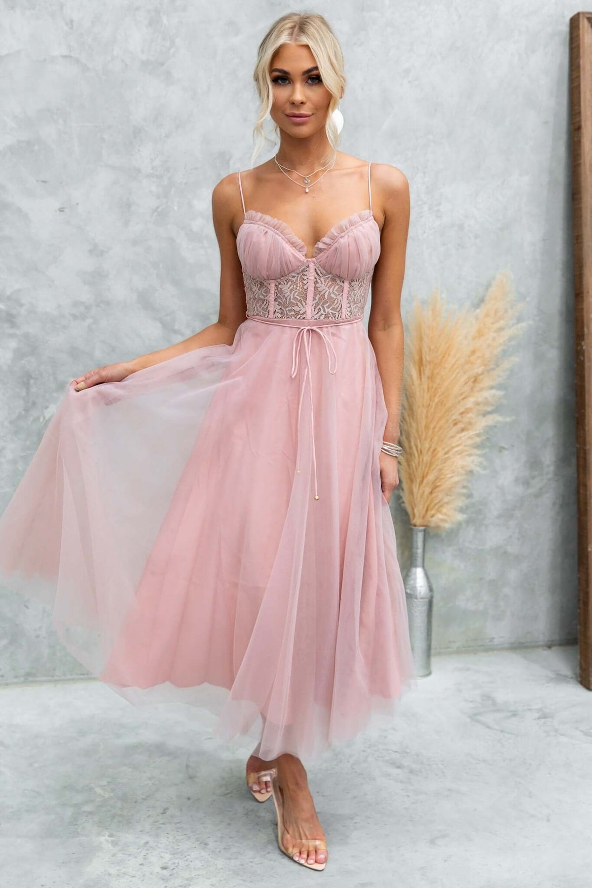 Model wearing the Wash Away Maxi Dress featuring tulle fabric, adjustable straps, lace detail, and removable tie.