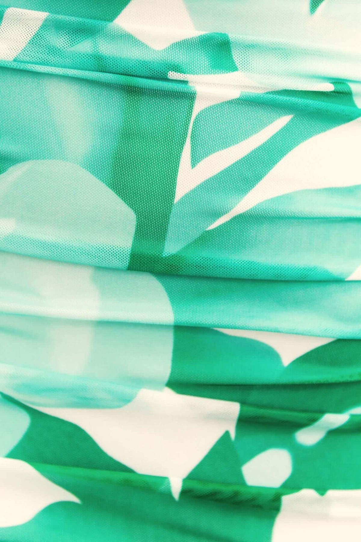 Close-up view of the green floral patterned fabric of a Stolen Kiss Maxi Dress, showcasing the soft texture and ruching detail.
