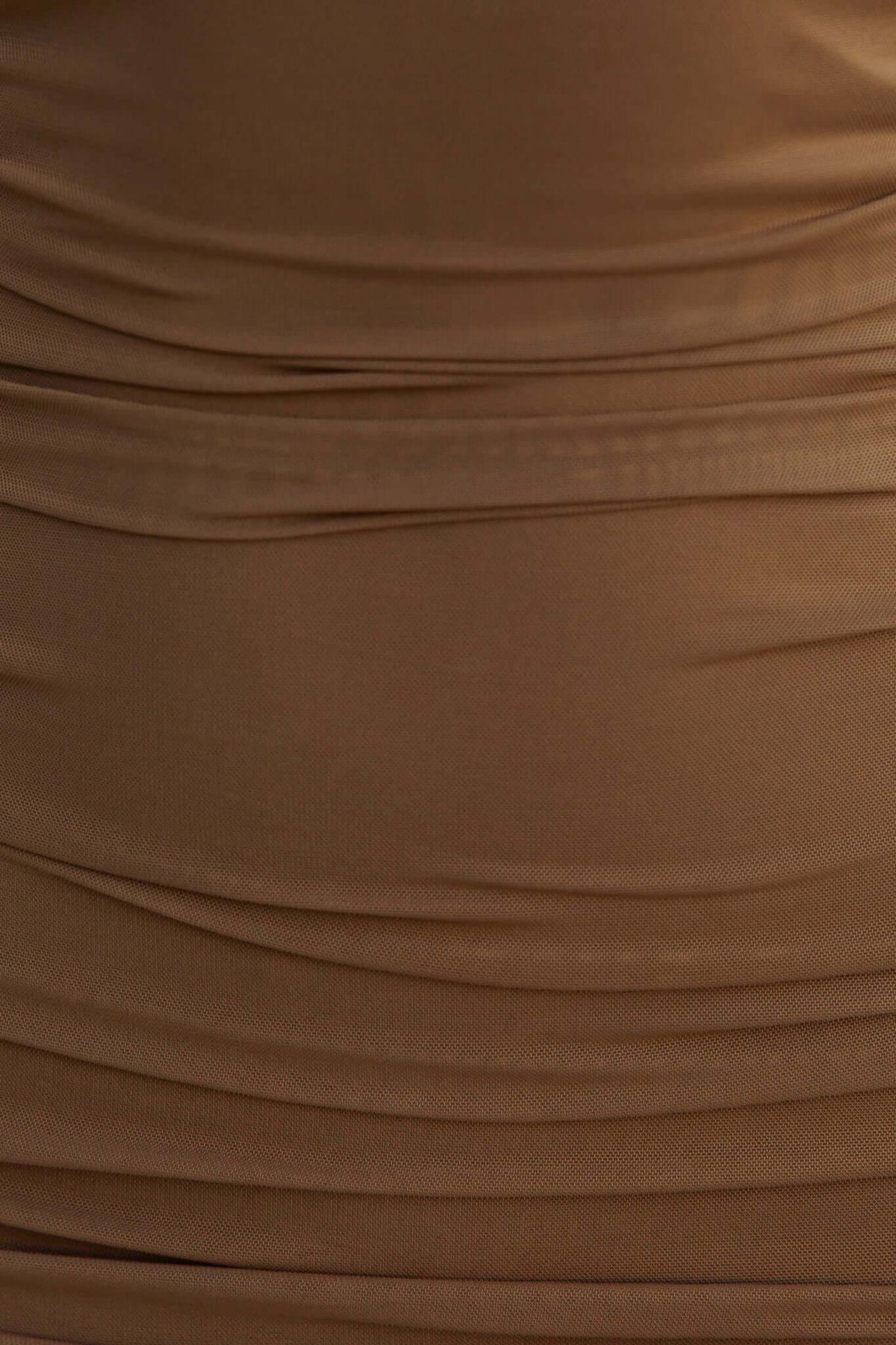 Close-up of textured brown fabric showcasing soft ruching, perfect for adding elegance to a maxi dress.