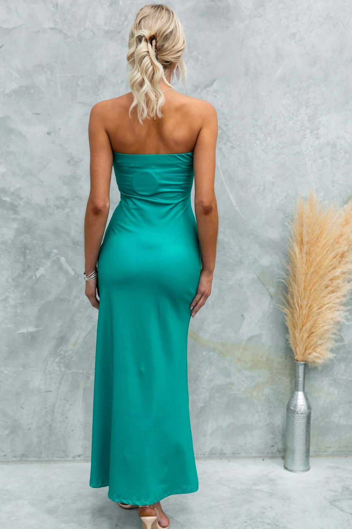 Back view of a model wearing a strapless teal Dyxon Maxi Dress with elastic neckline and stretch fabric.