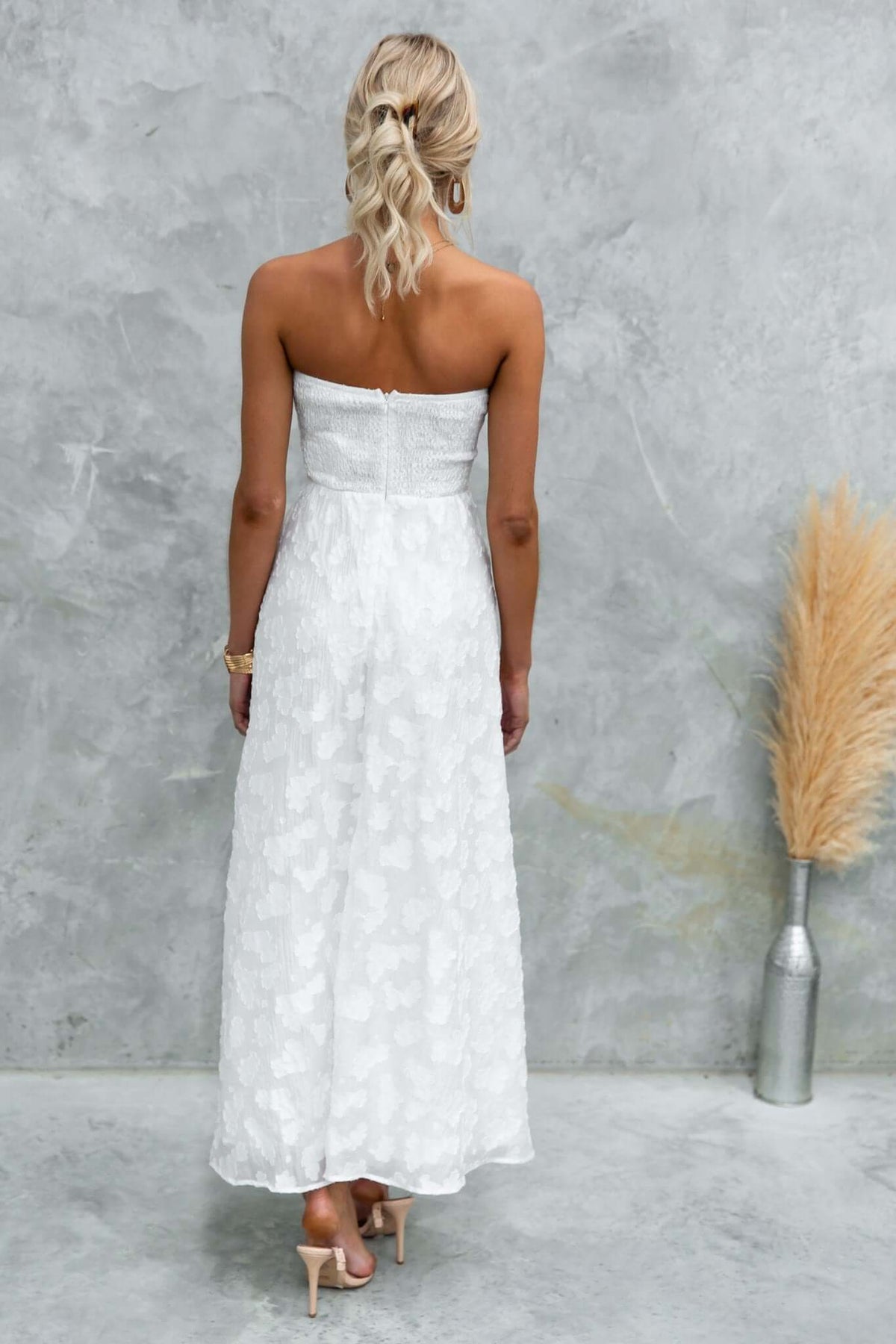 Ivrea Maxi Dress in white, strapless with delicate texture, shown from the back on a model against a neutral backdrop.