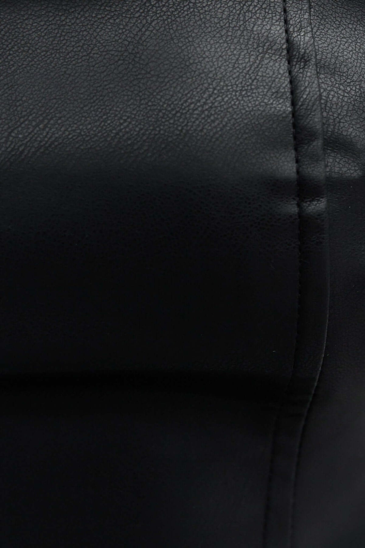 Close-up of the Modena Top, showcasing its sleek faux leather texture and stylish design.