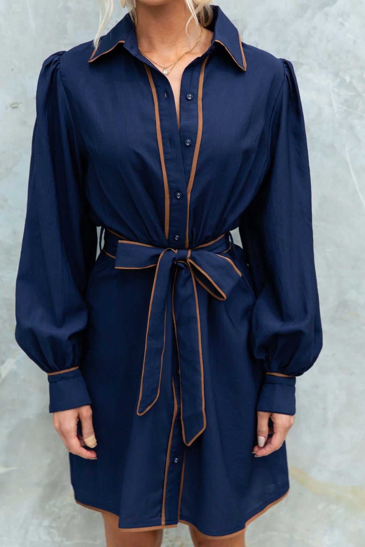 Pianolo Dress featuring a button-up front, elastic sleeves, and removable tie detail in navy with contrast piping.