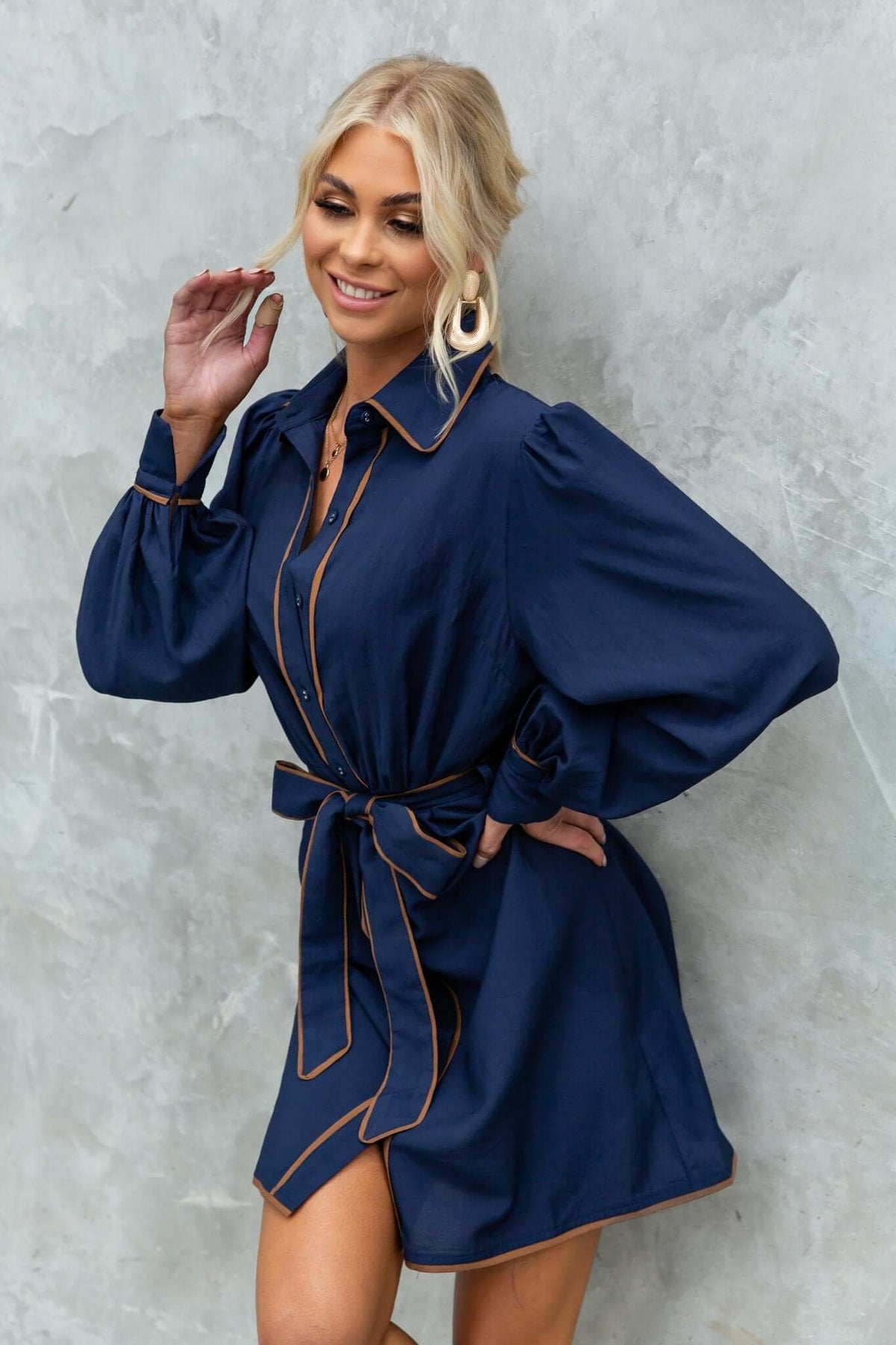 Model wearing a blue Pianolo dress with a button-up front and removable tie, showcasing a stylish casual look.