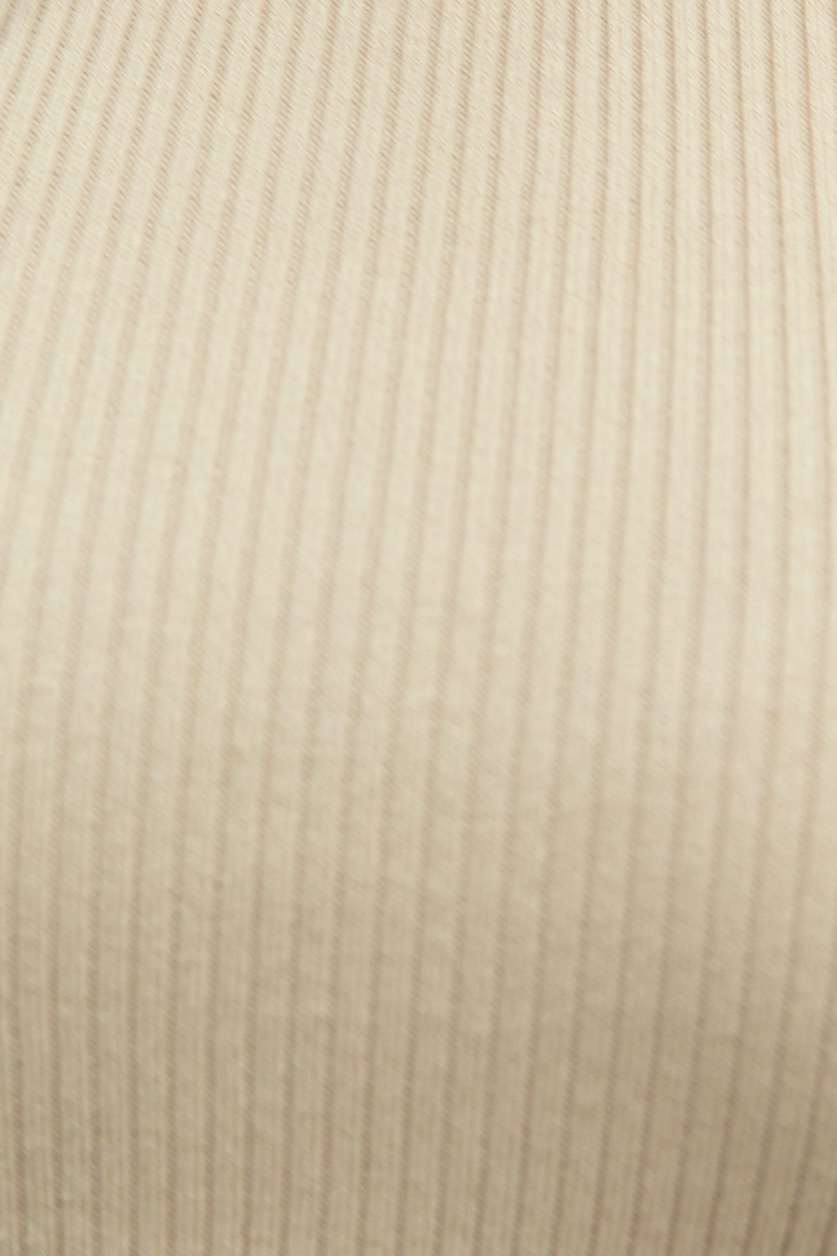 Close-up of a ribbed knit fabric in a neutral beige color, showcasing the texture and stretch of the material.