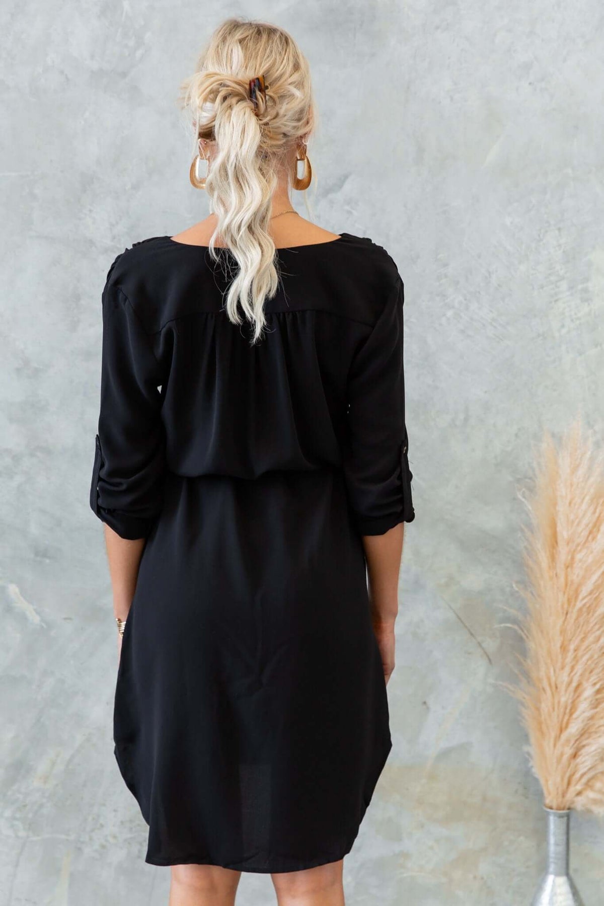 Back view of the Deklyn Dress in black with rolled sleeves and relaxed fit, showcasing soft fabric and stylish design.