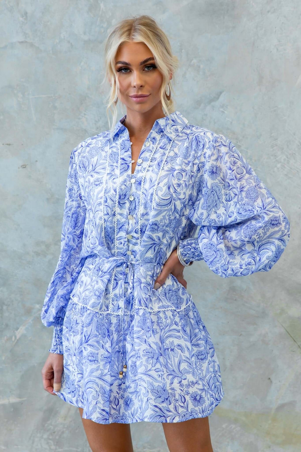 Alys Dress in light blue floral print with collar and button-up front, featuring elastic sleeves and removable tie.
