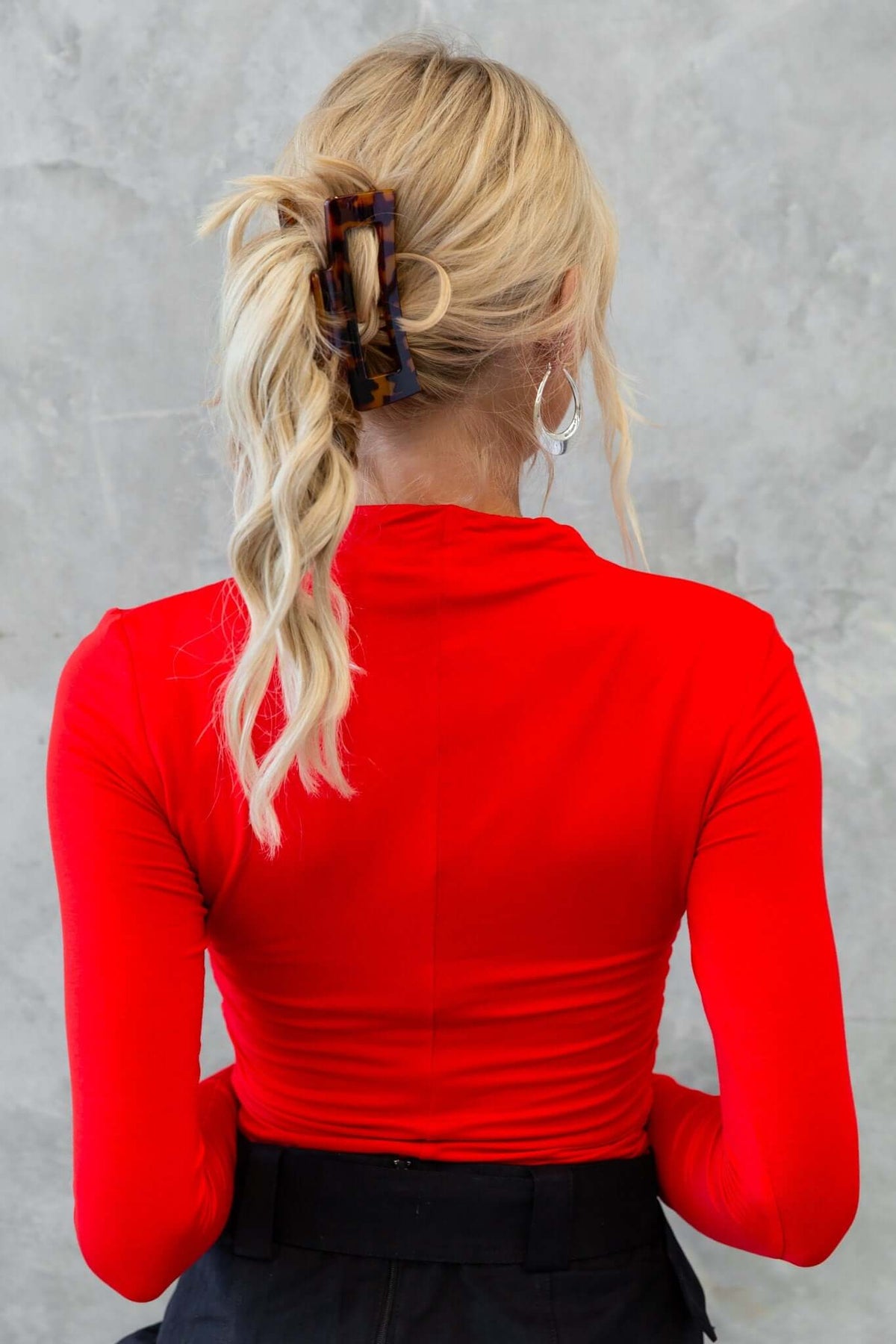 Back view of a woman wearing a red Rumba top paired with a black skirt, showcasing a stylish hairstyle.