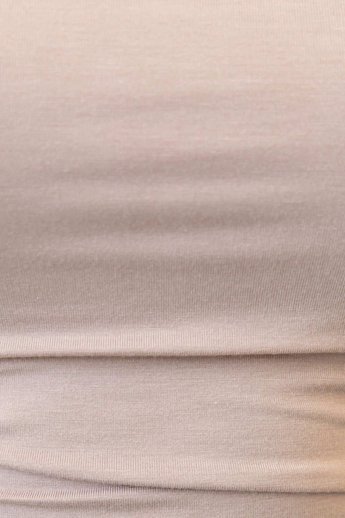 Close-up of Rumba Top fabric showcasing soft stretch material in a neutral beige color.