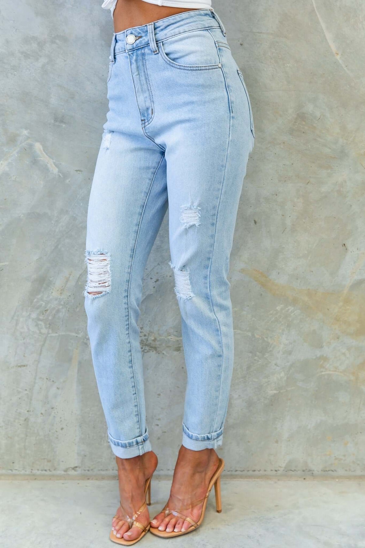 Light blue amber jeans with mid-high waist, front & back pockets, and distressed rips for a trendy look.