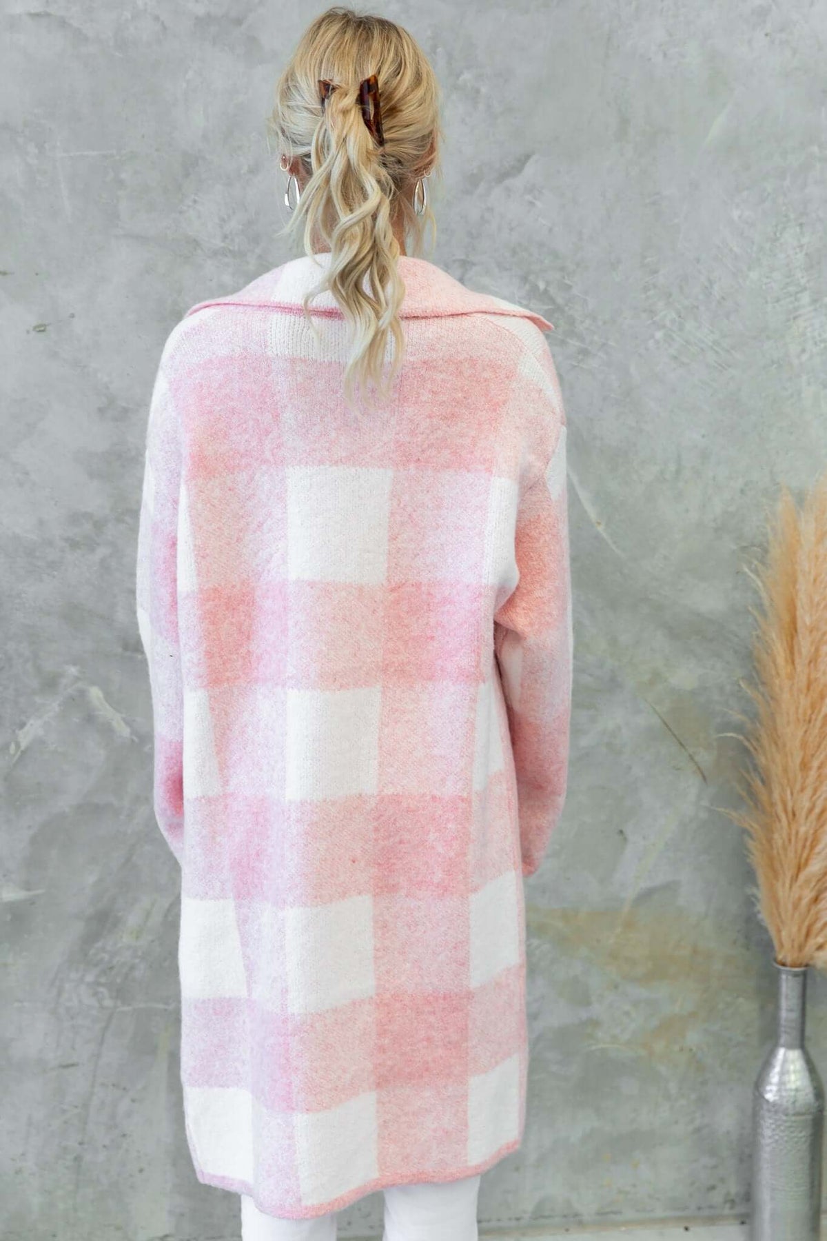 Back view of a pink and white checkered Fatale Cardigan, featuring a longline fit and collar, styled for a cozy look.