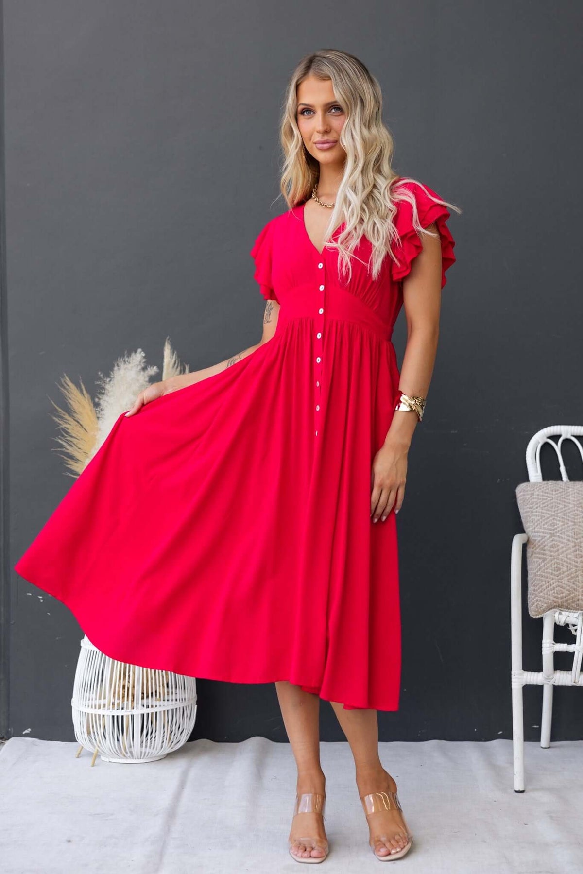 Bright red Joelle Midi Dress featuring a button-up front, pockets, and ruffled sleeves, perfect for a chic summer look.