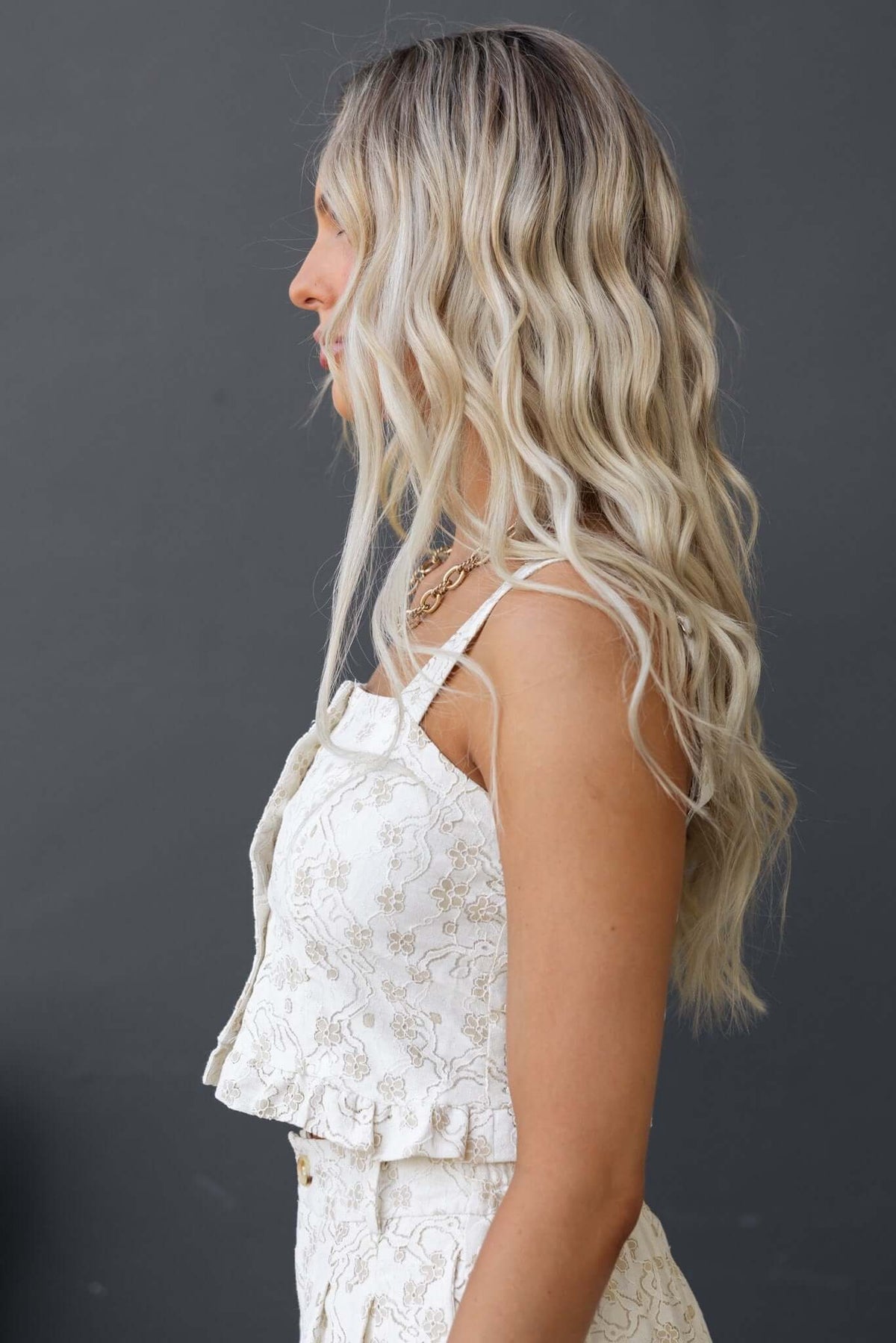 Profile view of a woman wearing the Ella Top, featuring adjustable straps and a delicate floral design.