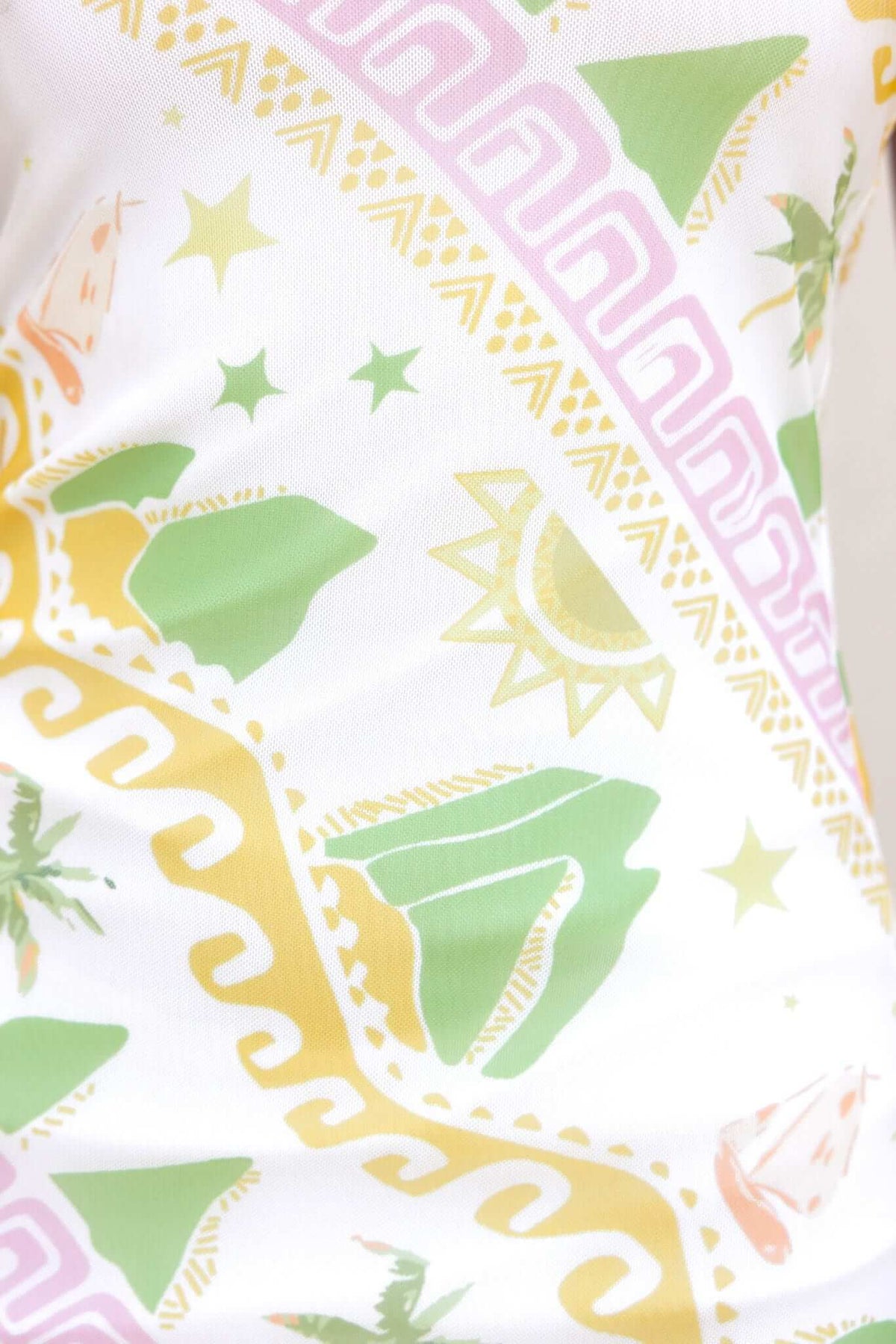Colorful patterned fabric of the Orinzo Maxi Dress featuring sun, palm trees, and geometric designs.