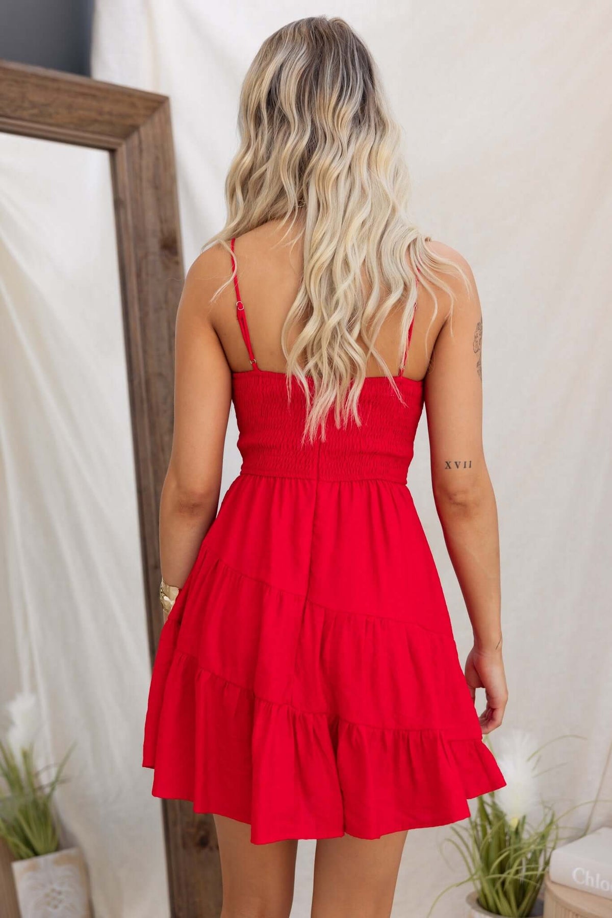 Back view of a red Eider Dress featuring adjustable straps and a tiered design.