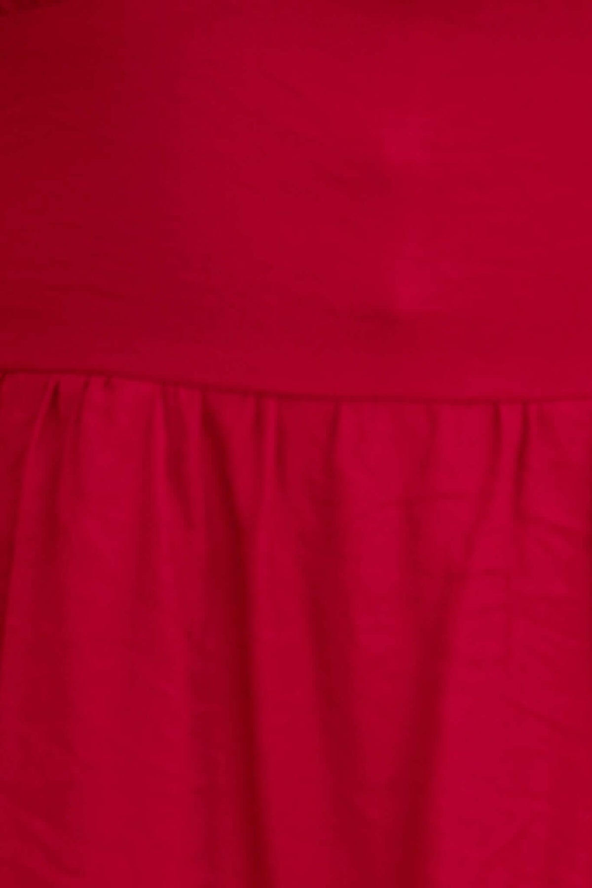 Close-up of Eider Dress in vibrant red, featuring adjustable straps and an elasticized back for a comfortable fit.