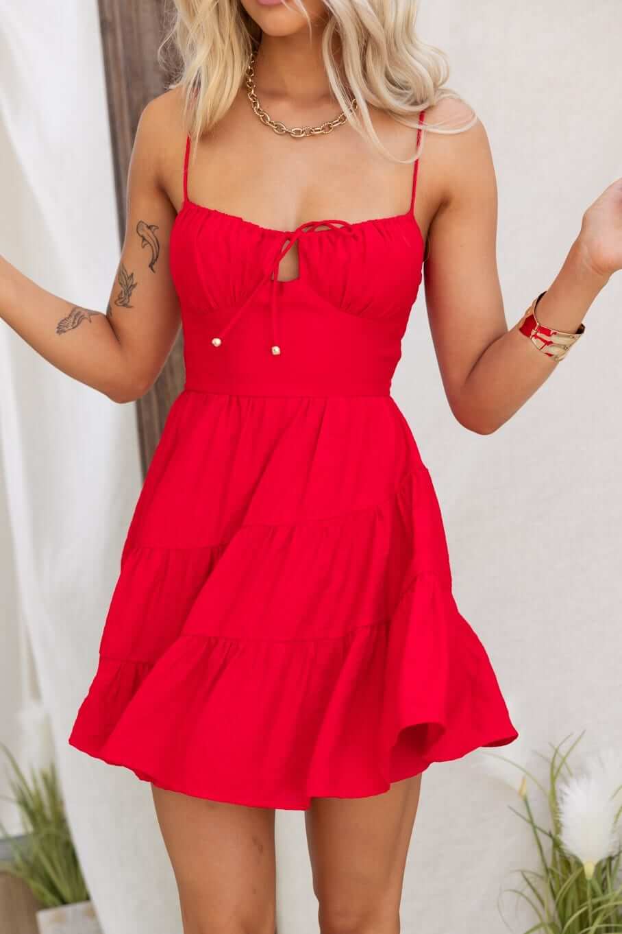 Eider Dress in vibrant red, featuring adjustable straps, bust tie, and playful tiered design.